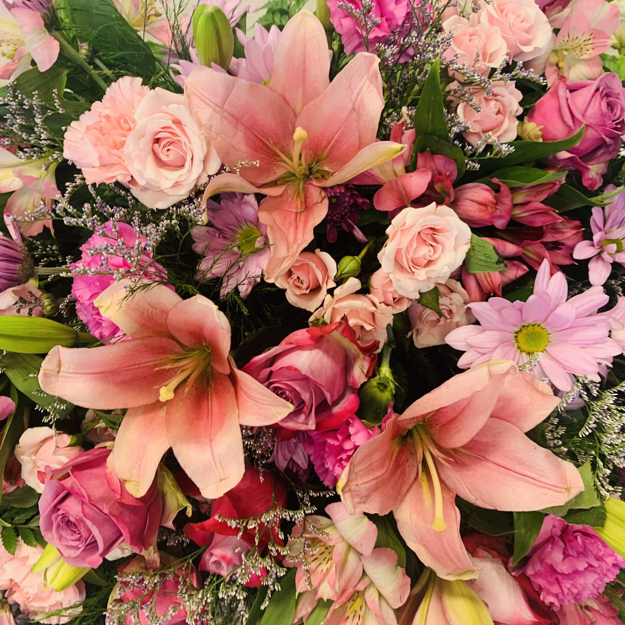 Casket spray of roses and lilies of pastel pinks and lavender purple Casket spray of roses and lilies of pastel pinks and lavender purple