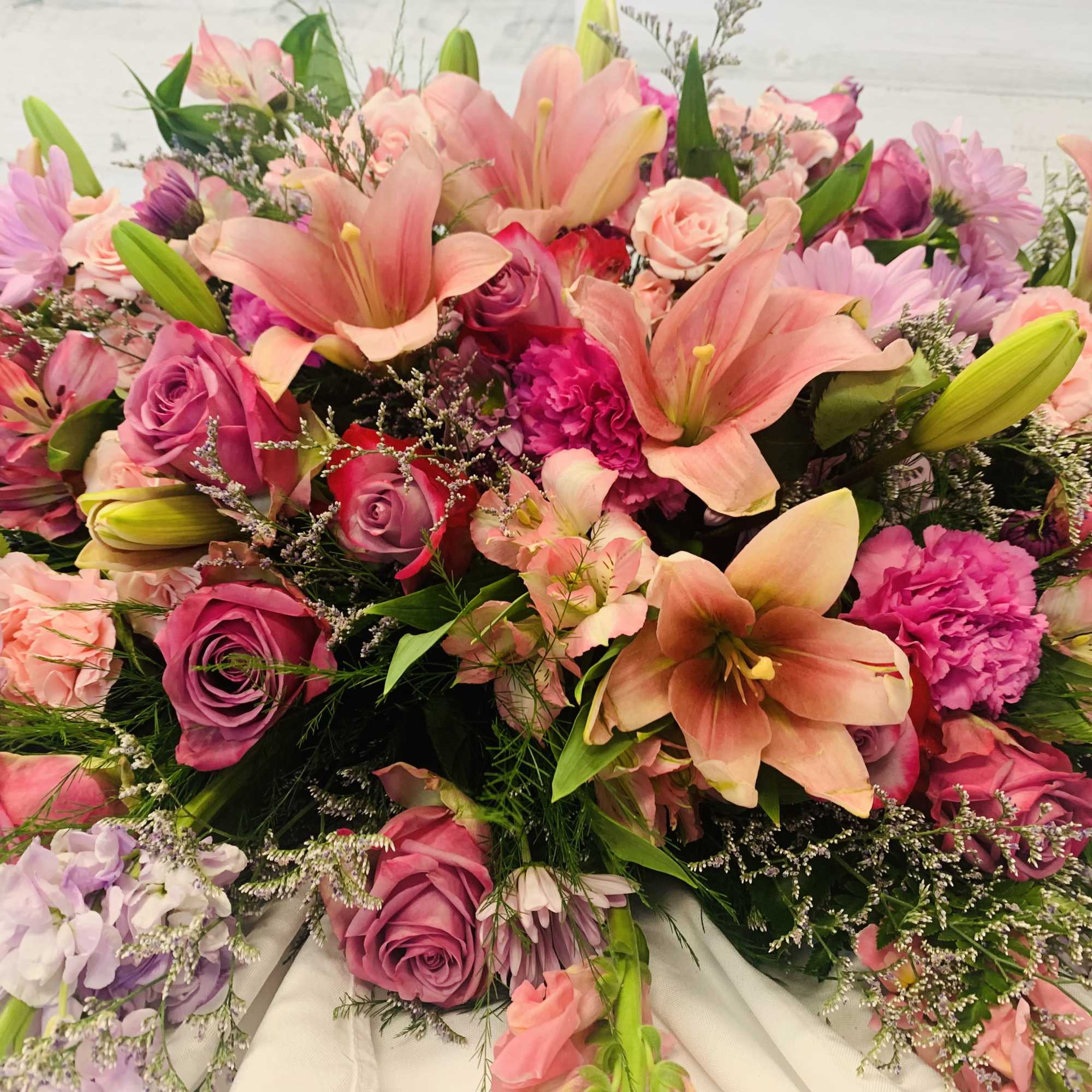 Casket spray of roses and lilies of pastel pinks and lavender purple Casket spray of roses and lilies of pastel pinks and lavender purple