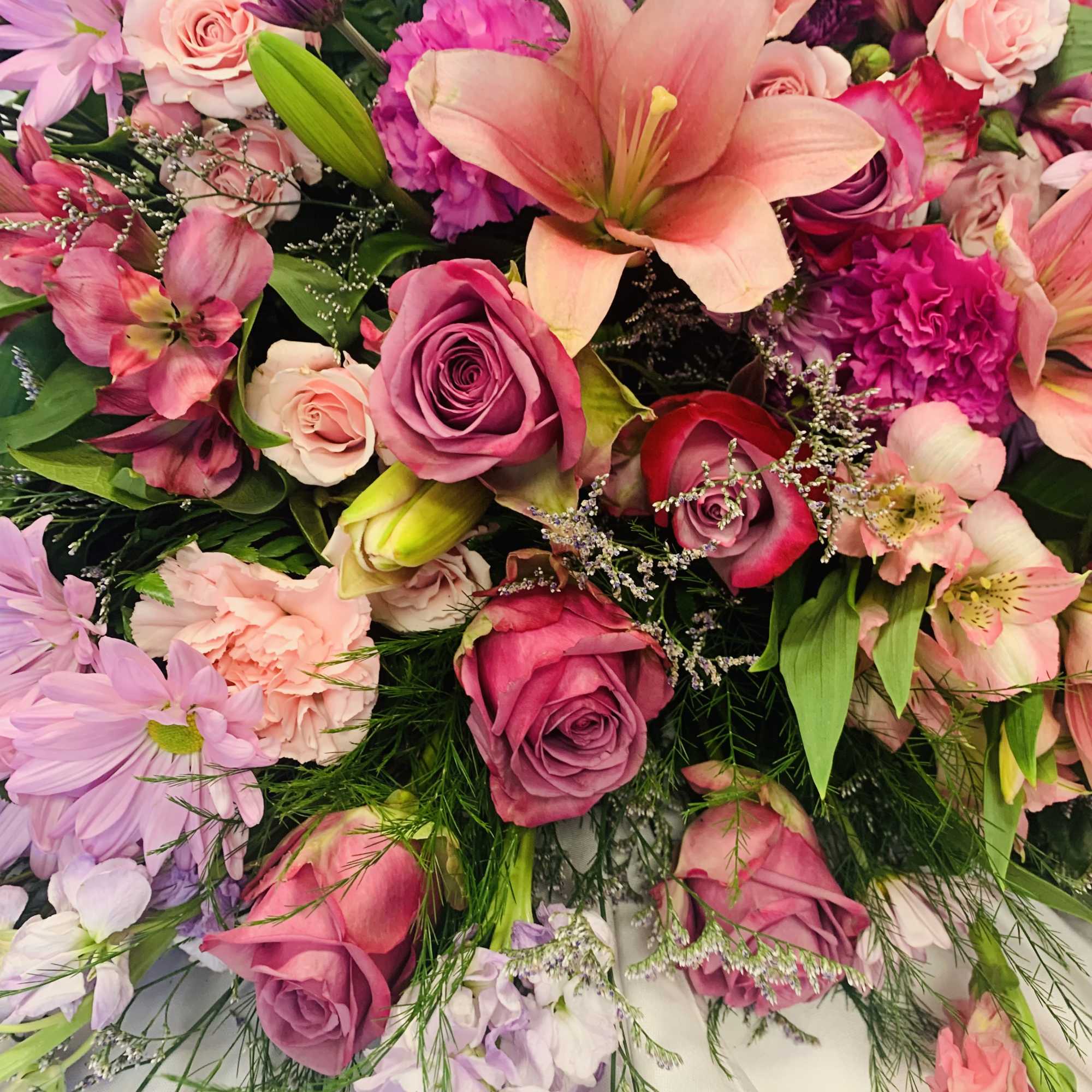 Casket spray of roses and lilies of pastel pinks and lavender purple Casket spray of roses and lilies of pastel pinks and lavender purple