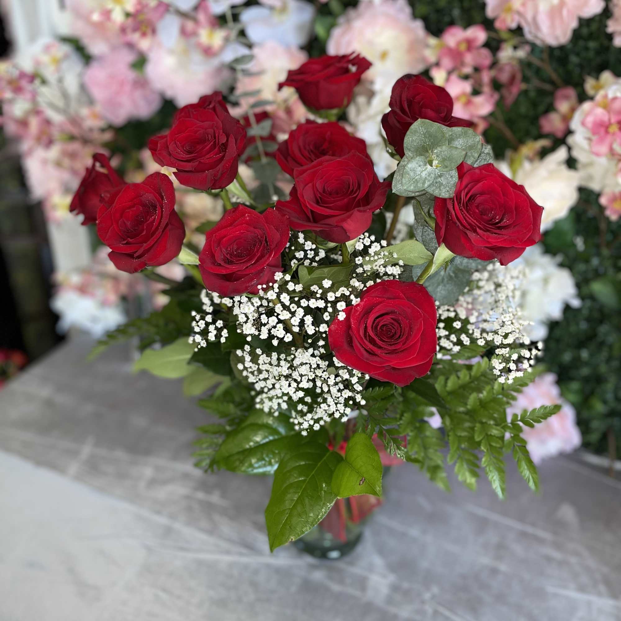 This gorgeous arrangement has red roses and fresh greens.