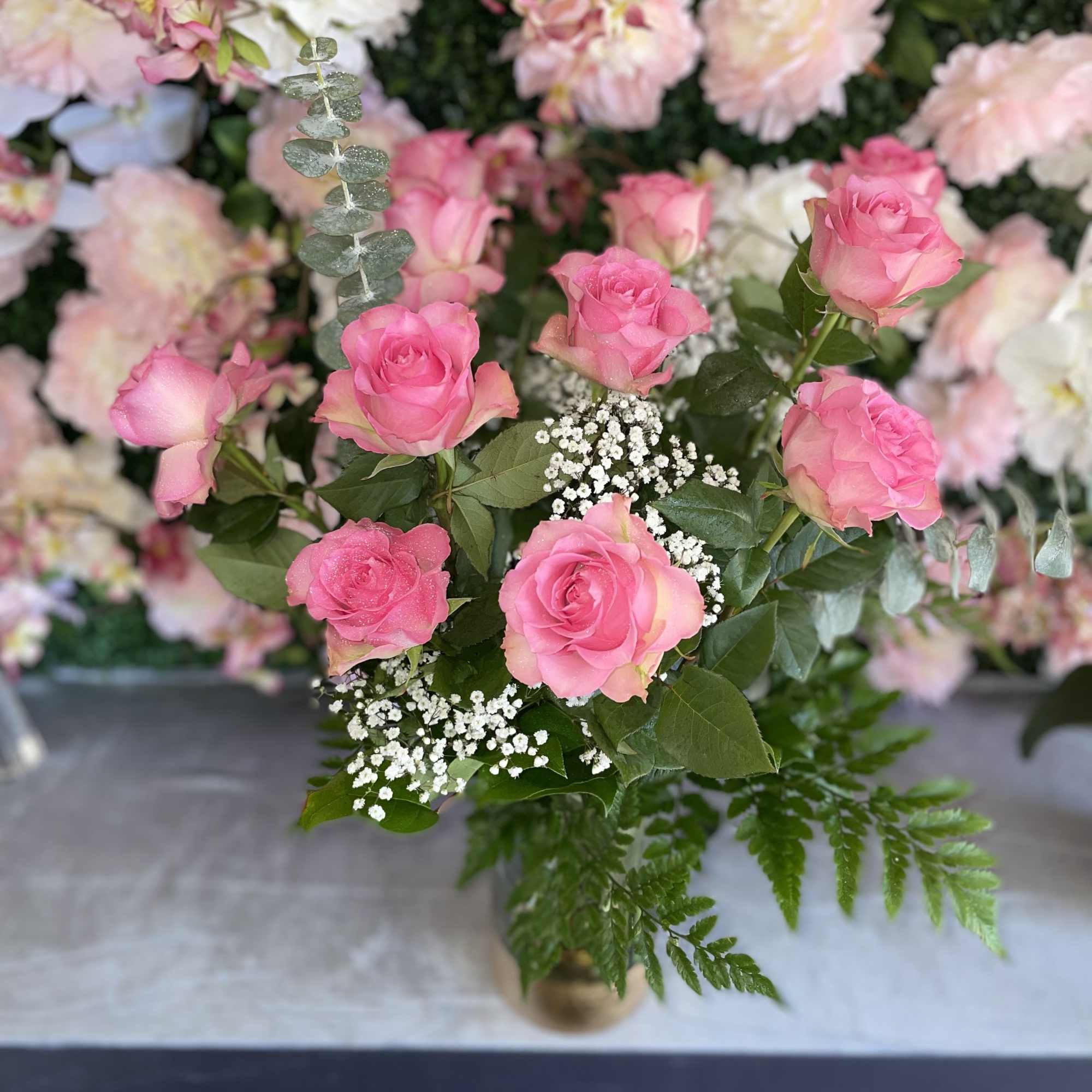 This sweet arrangement has pink roses and fresh greens 