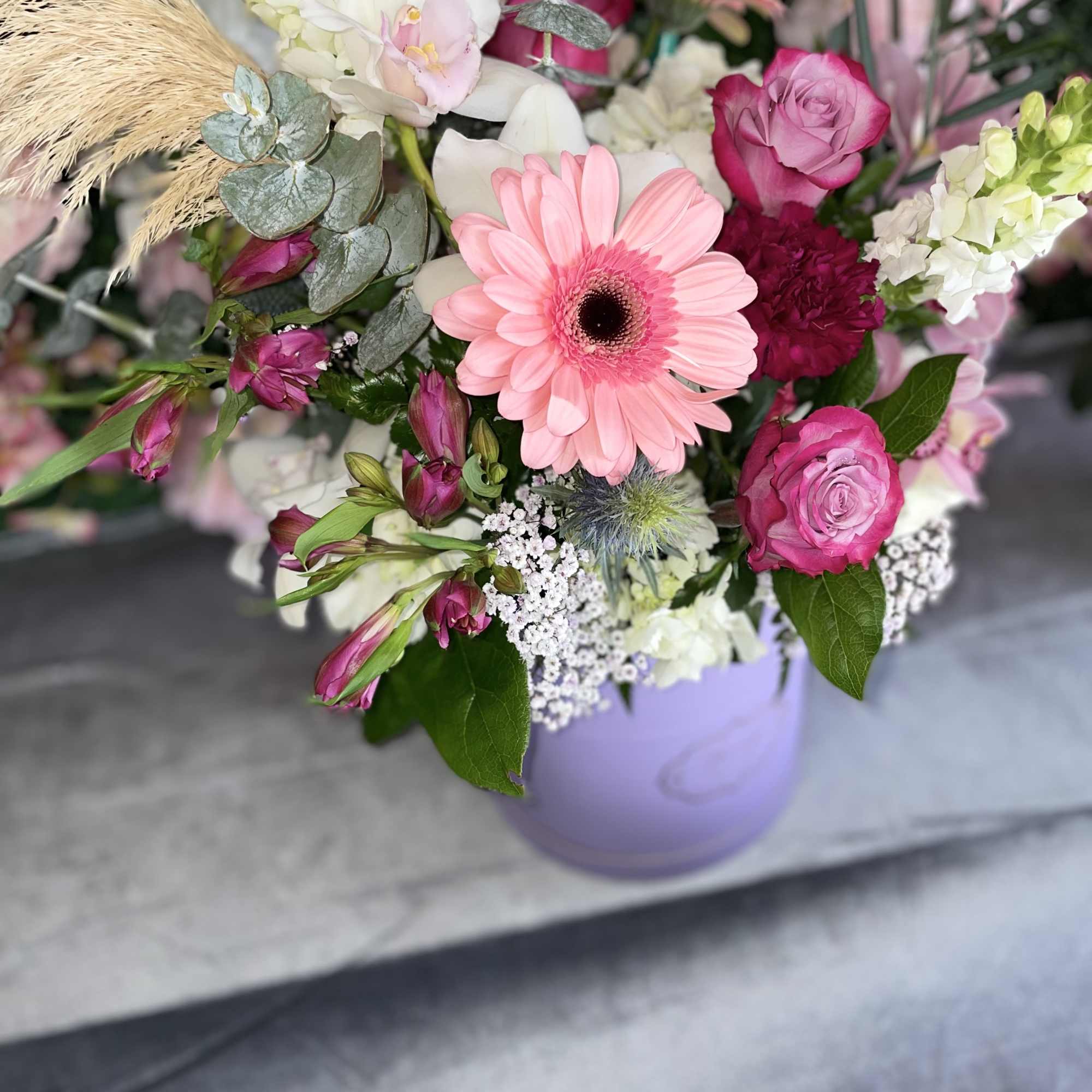 This beautiful arrangement has the perfect colors, pink gerbera, lavender roses, white