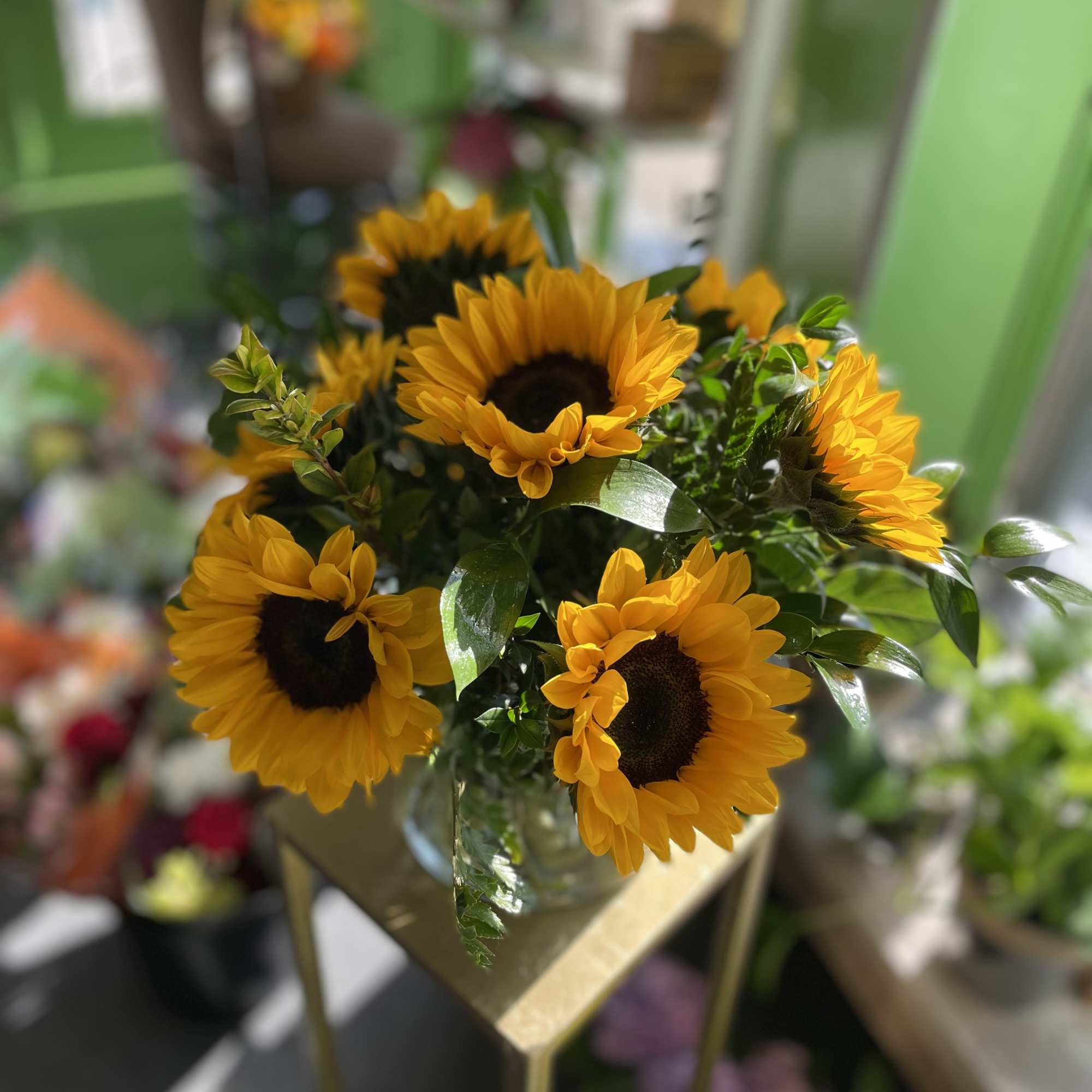 This bright and beautiful arrangement has fresh cut sunflowers.