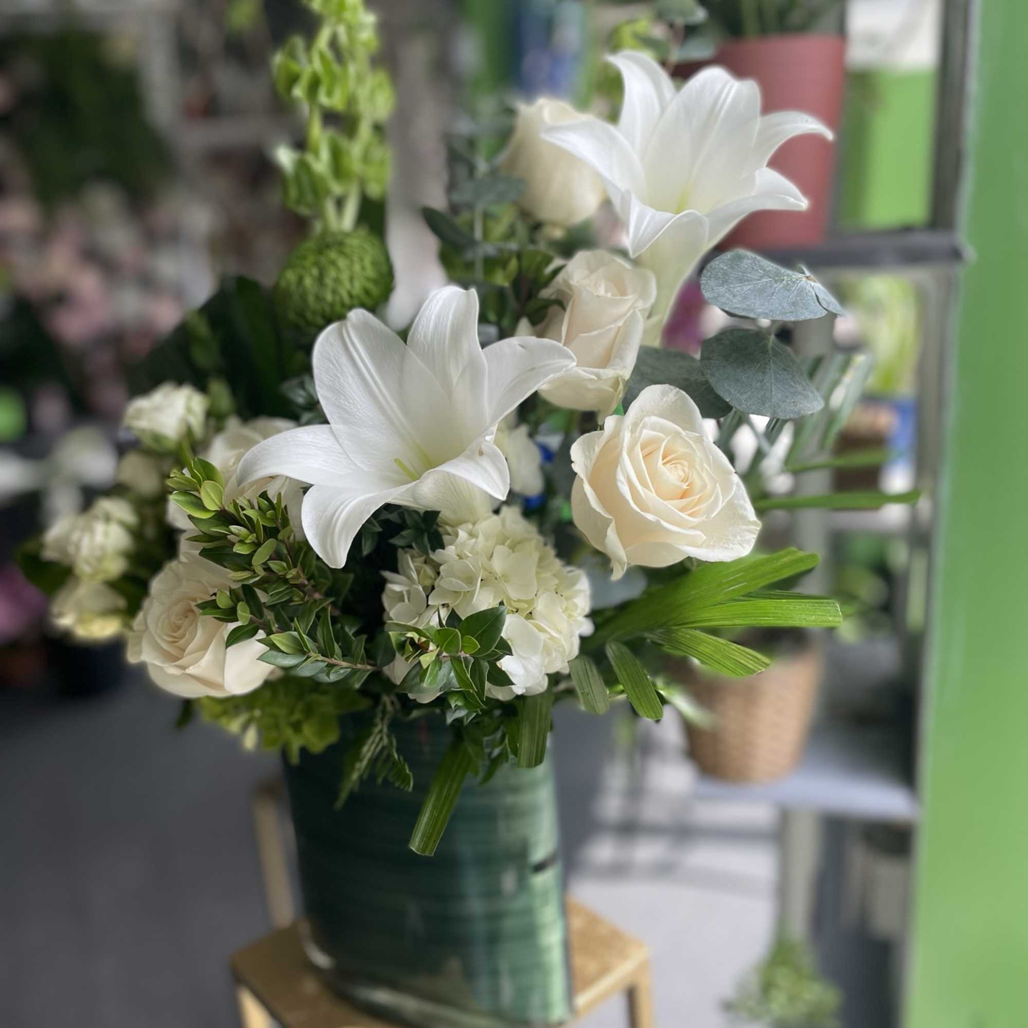 This beautiful arrangement has gorgeous white fresh flowers and white lilies, white