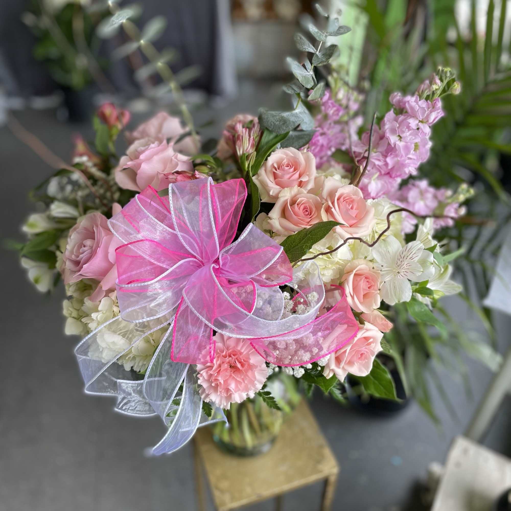 This lovely arrangement has pink spray roses, pink roses, white hydrangea, pink