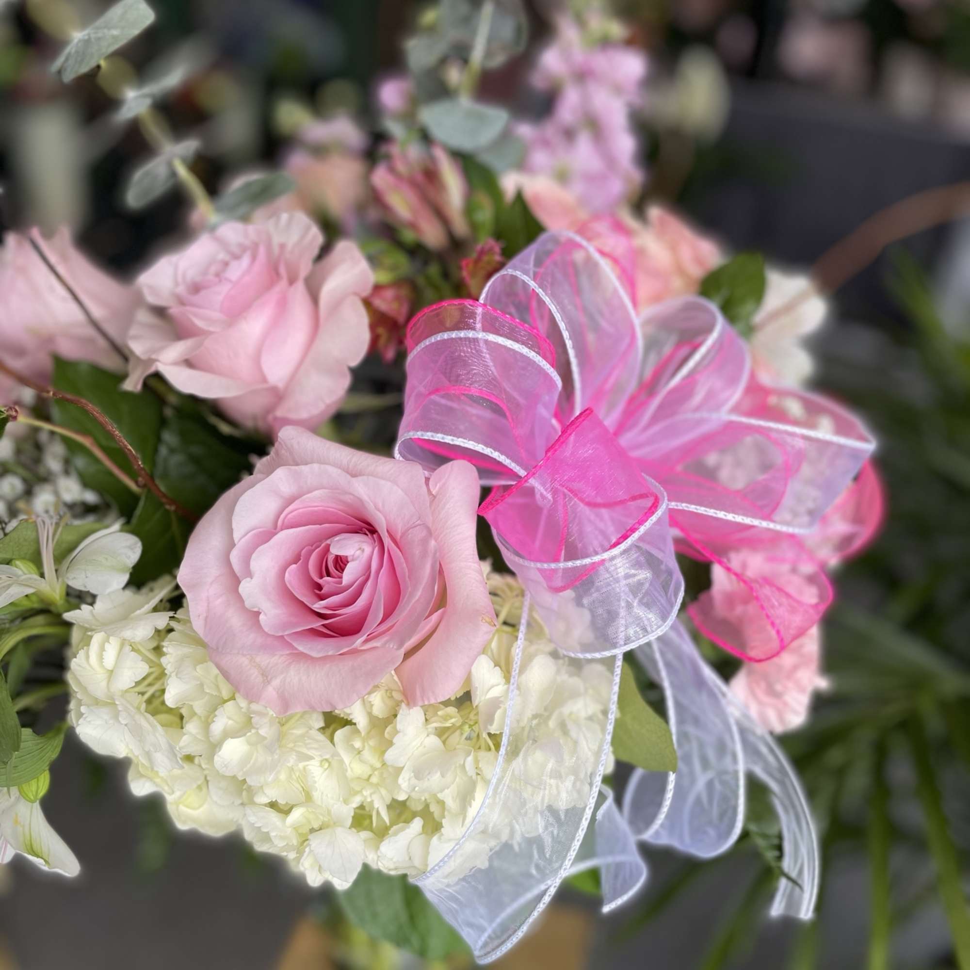 This lovely arrangement has pink spray roses, pink roses, white hydrangea, pink