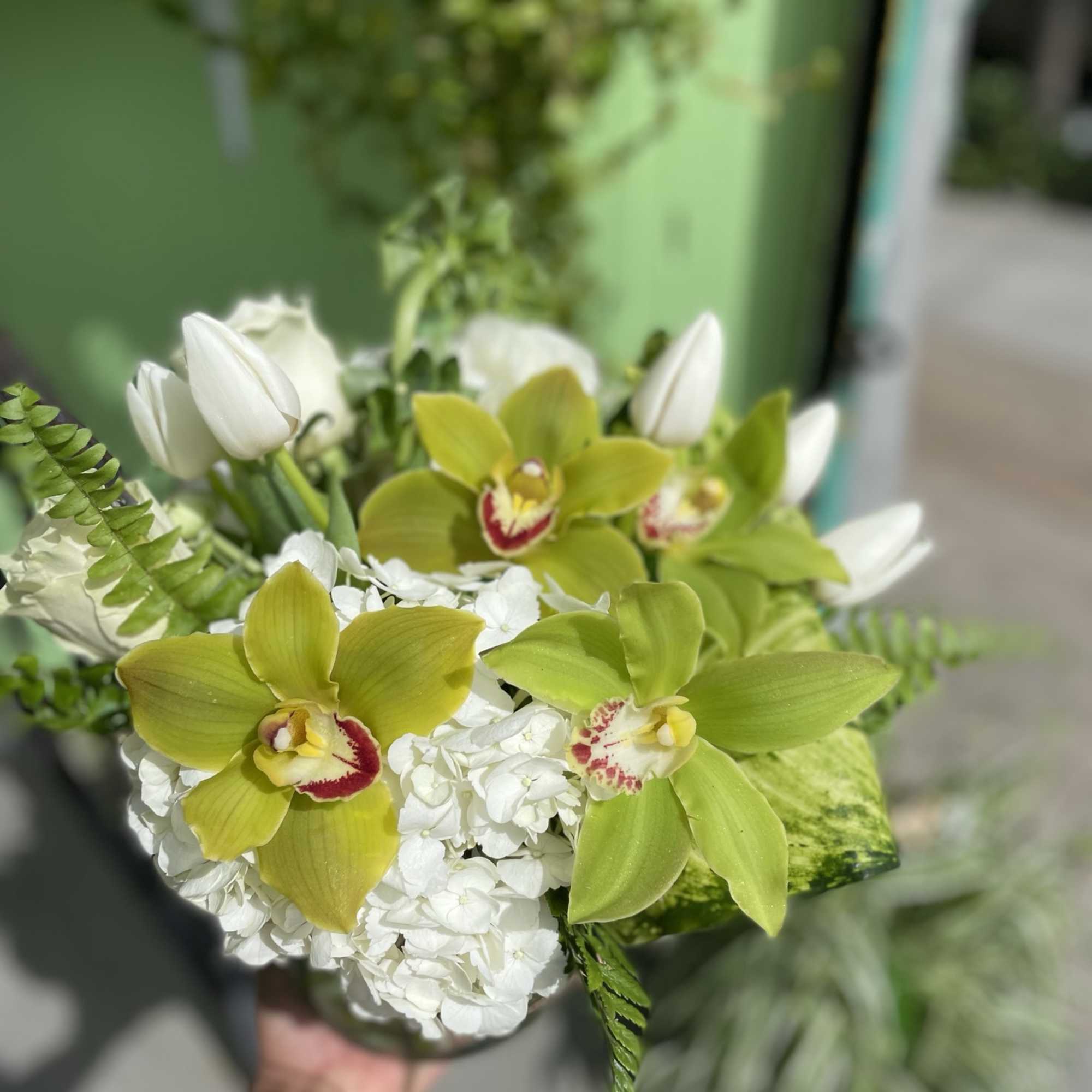 This beautiful arrangement has nice colors of flowers it has green orchid