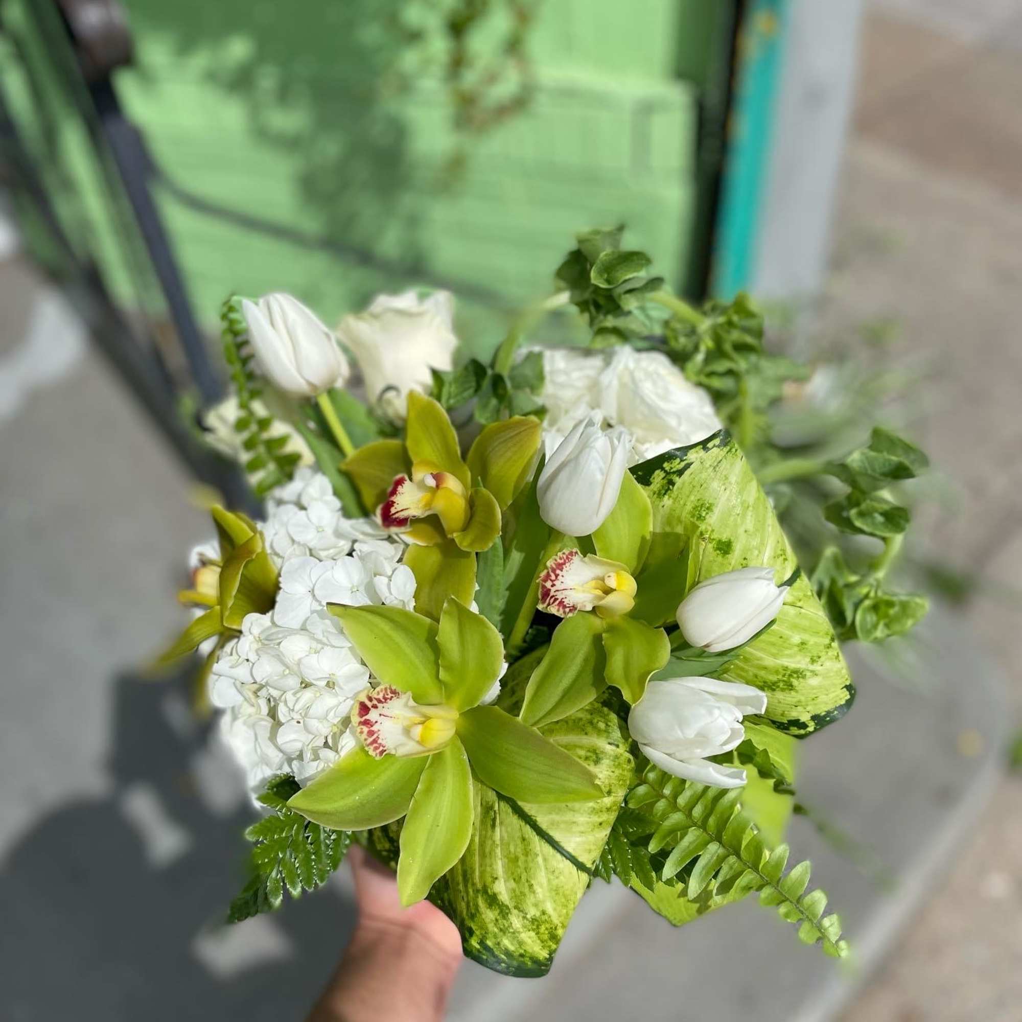 This beautiful arrangement has nice colors of flowers it has green orchid