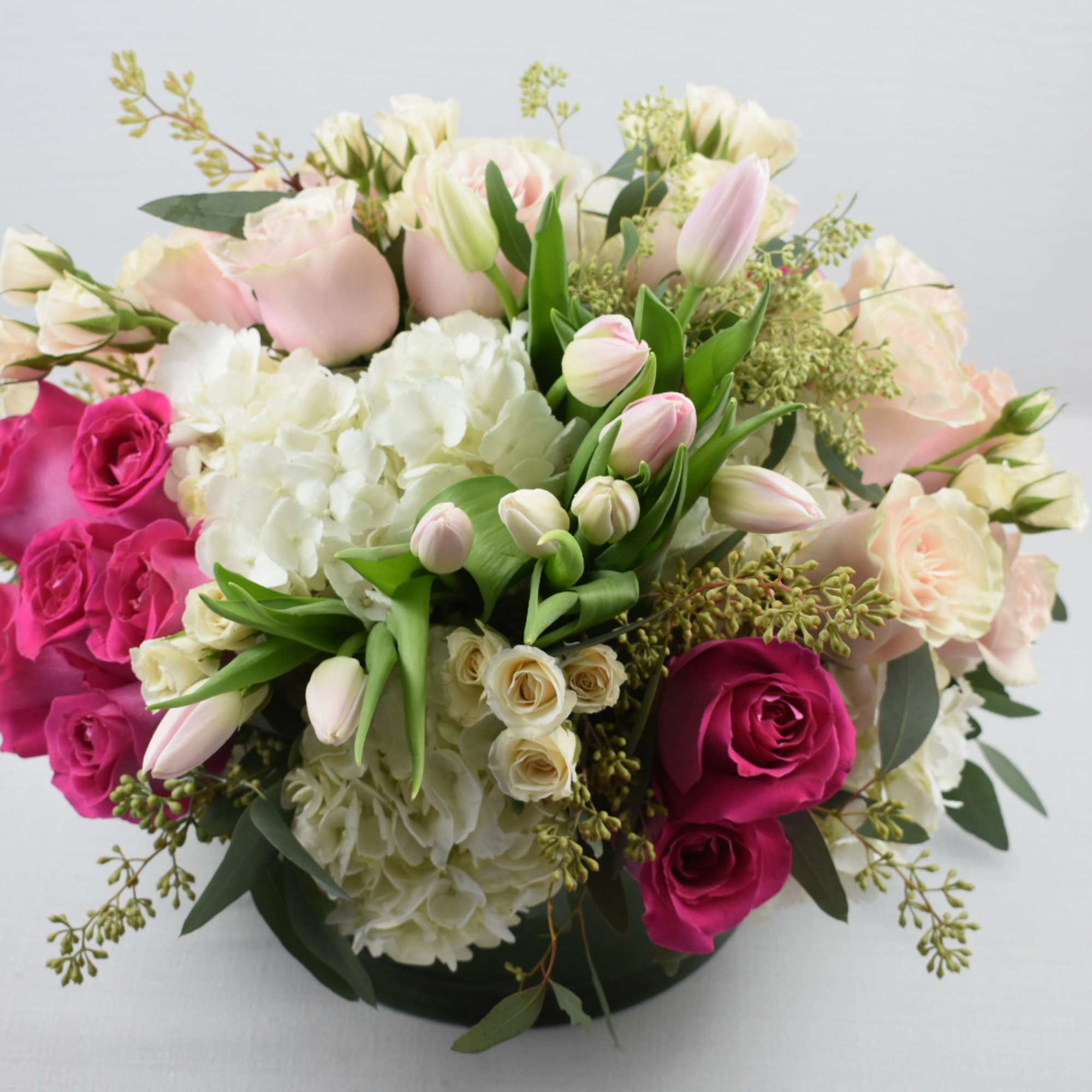 round low glass vace 
perfectly arranged with some pink shades Ecuadorian roses