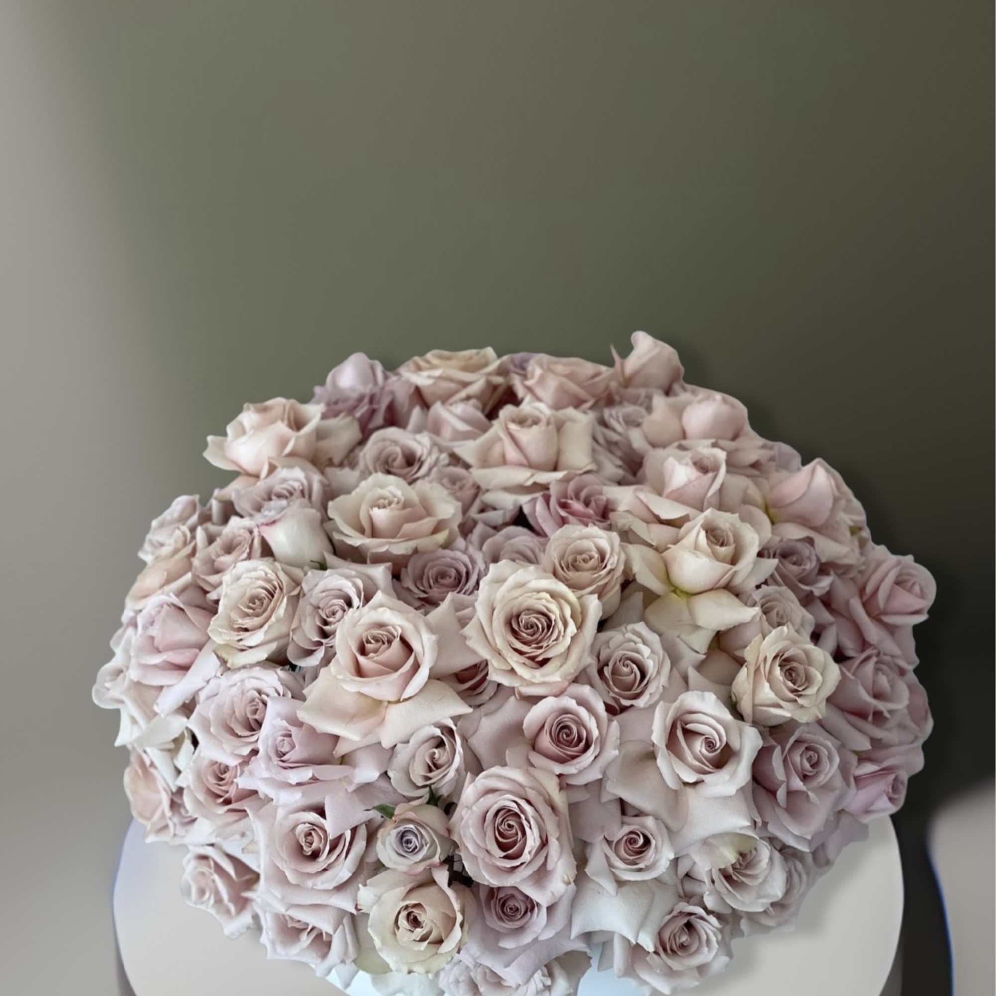This arrangement comes in a clay round vase filled with quicksand roses