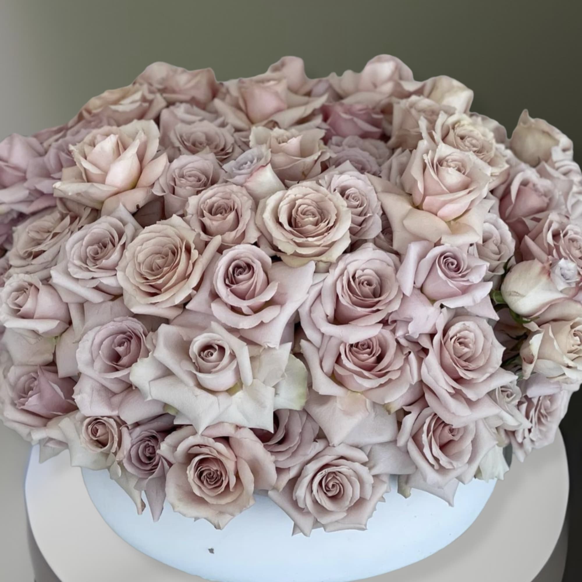 This arrangement comes in a clay round vase filled with quicksand roses