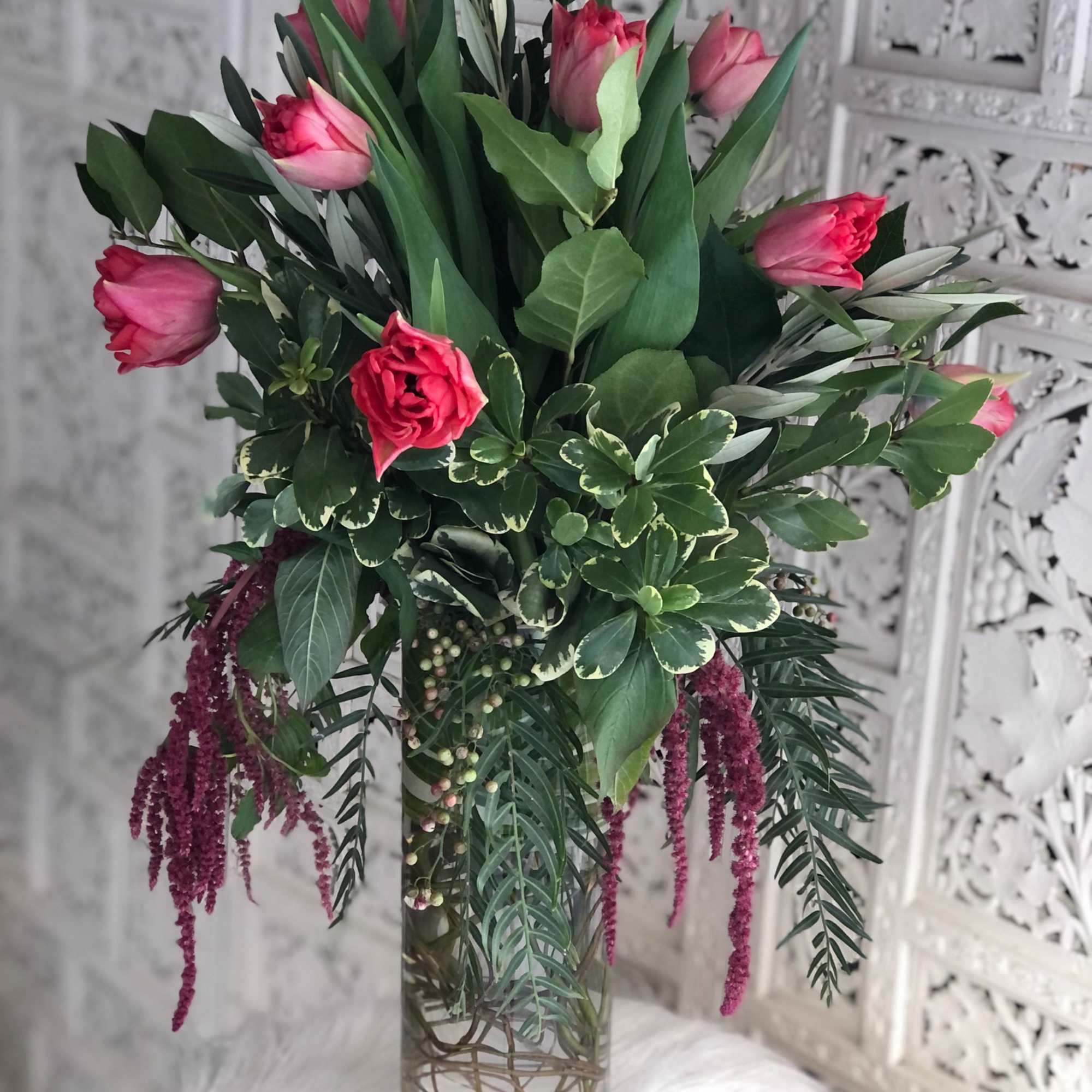 Unique Tulip design in a tall cylinder vase filled with curly willow