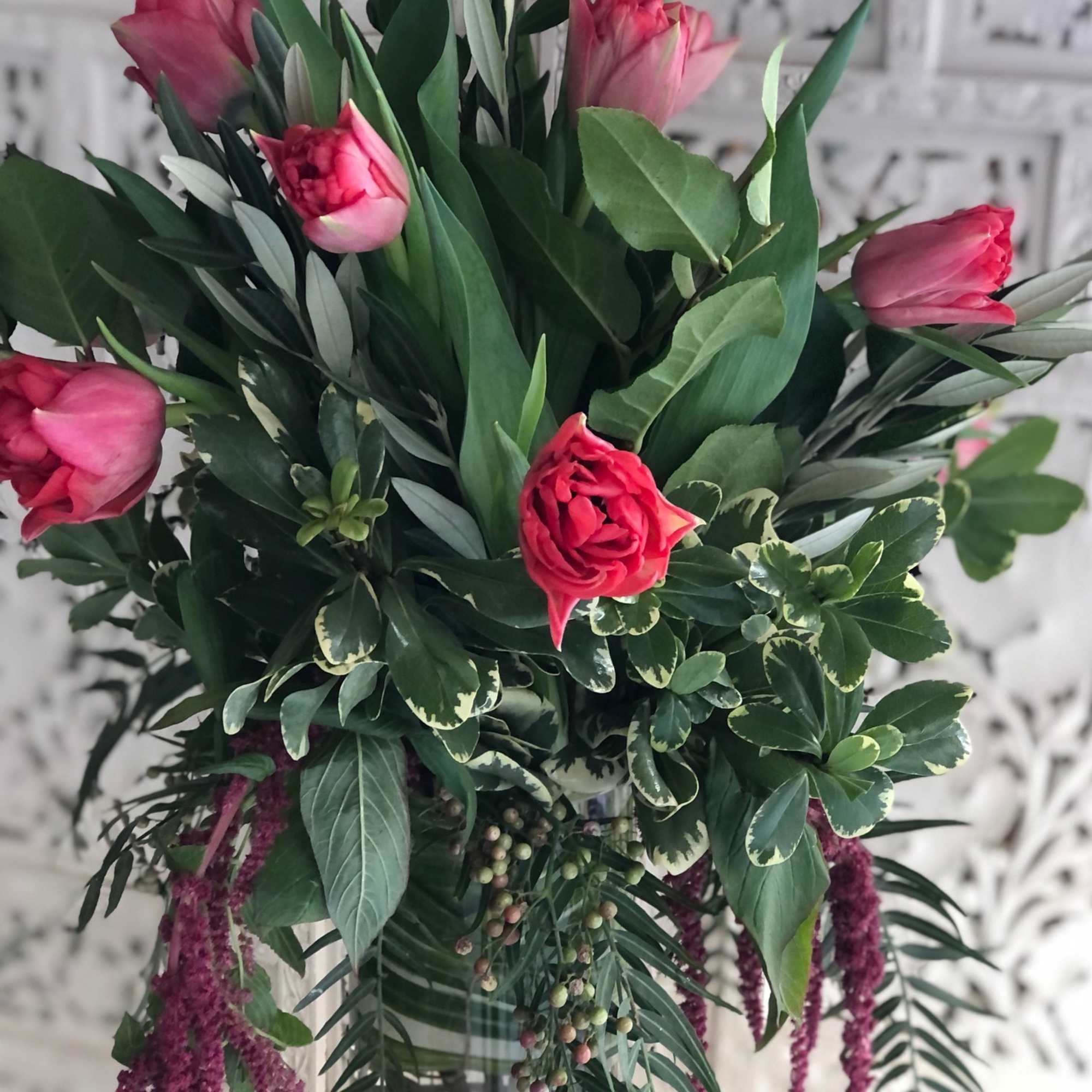 Unique Tulip design in a tall cylinder vase filled with curly willow