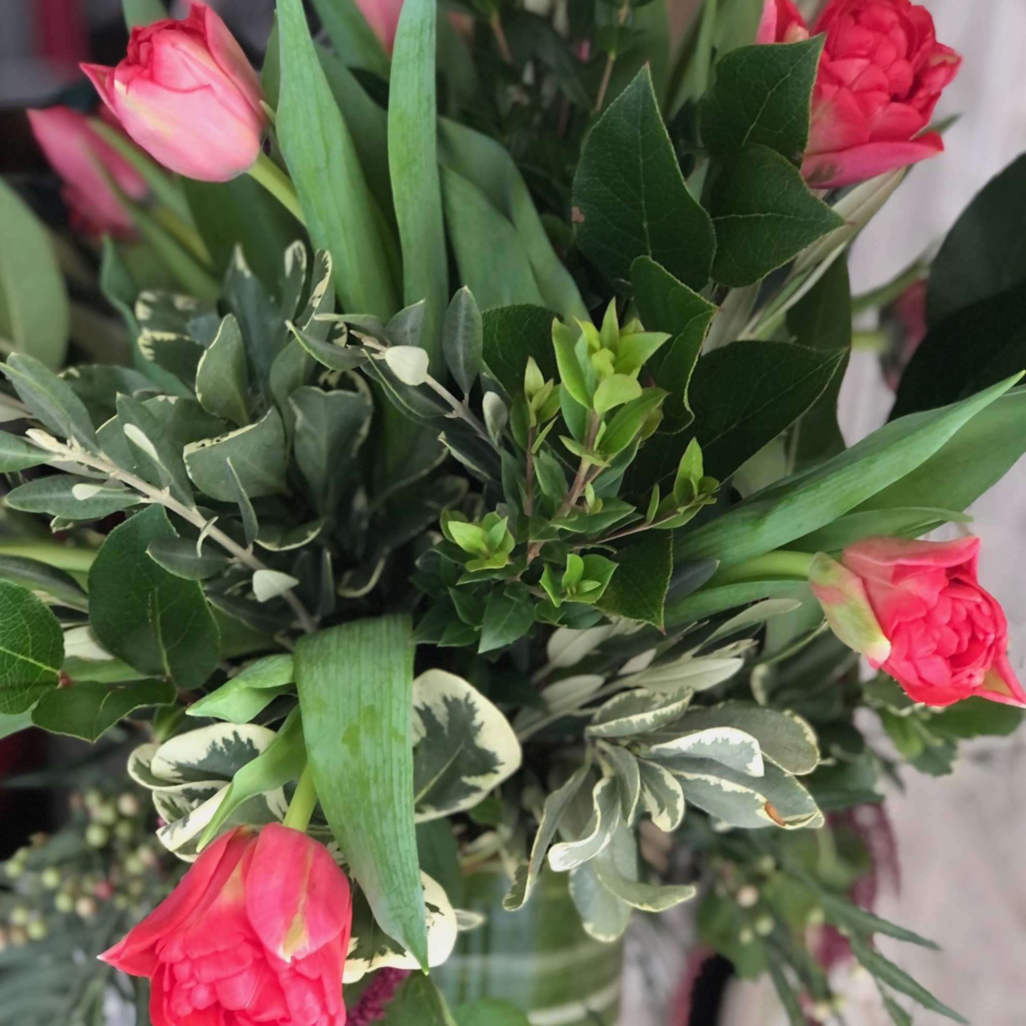 Unique Tulip design in a tall cylinder vase filled with curly willow