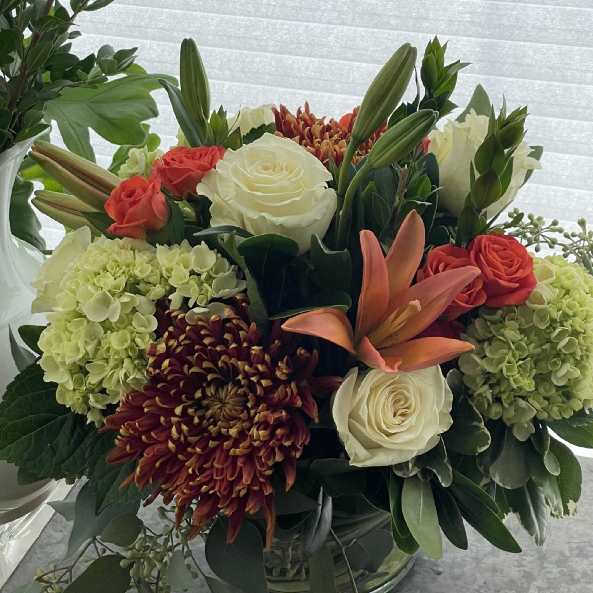 A festive mix of premium fall blooms such as lilies, roses, hydrangea