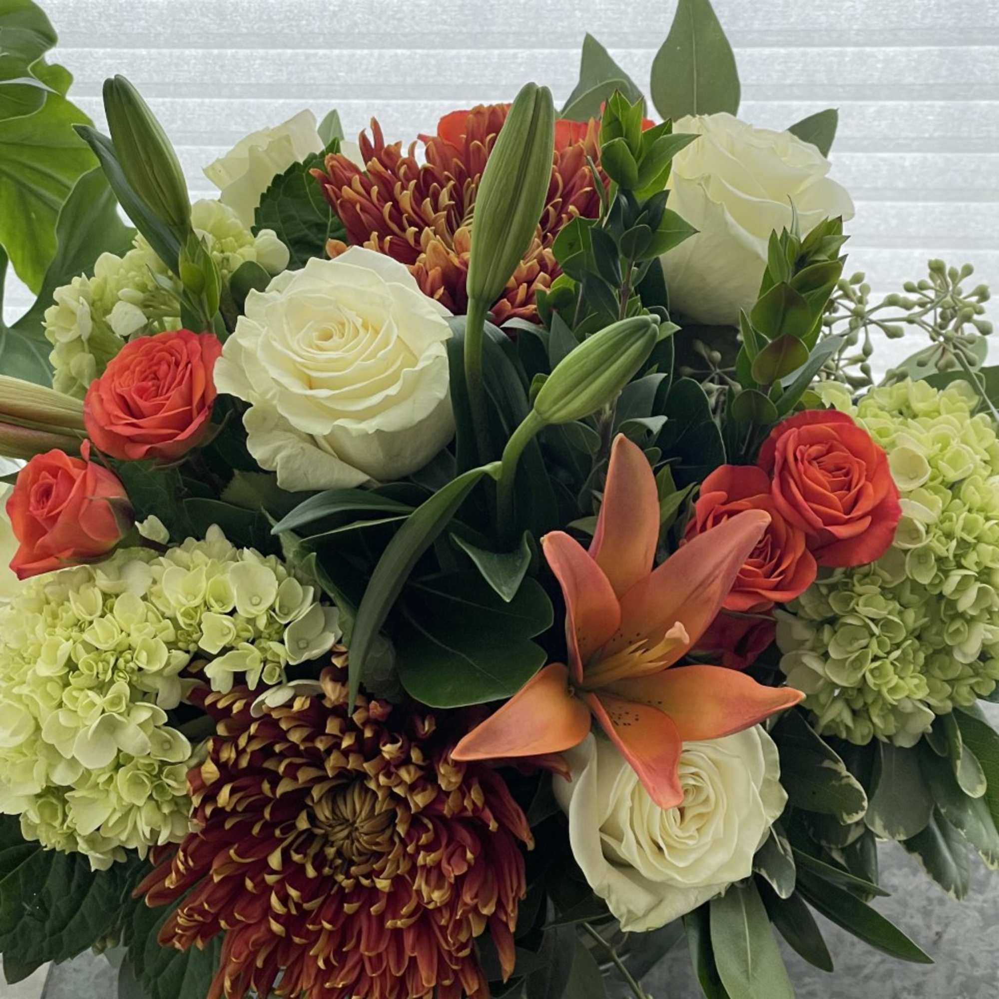 A festive mix of premium fall blooms such as lilies, roses, hydrangea
