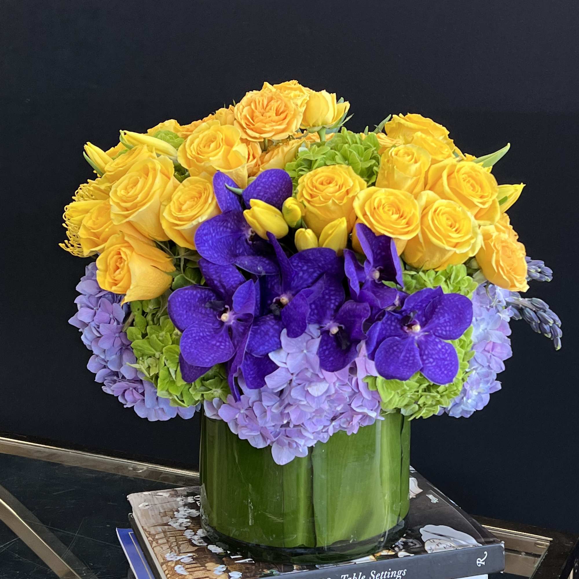 A vibrant arrangement in a sleek cylinder container, overflowing with the most