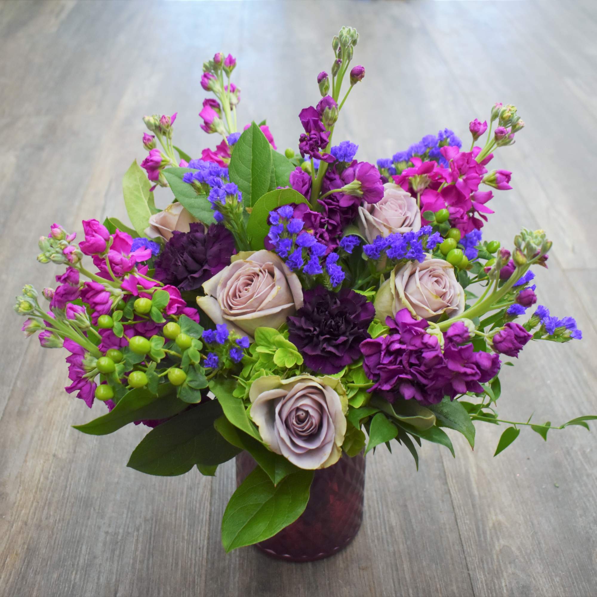 A mix of lavender roses, green hydrangea, fuchsia stock, plum carnations, purple