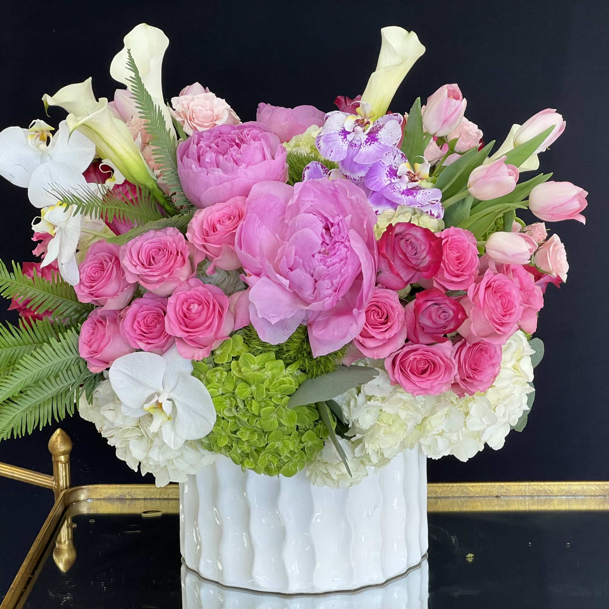 White hydrangeas, jeweled white cymbidium orchids, lavender and pink roses, and pale