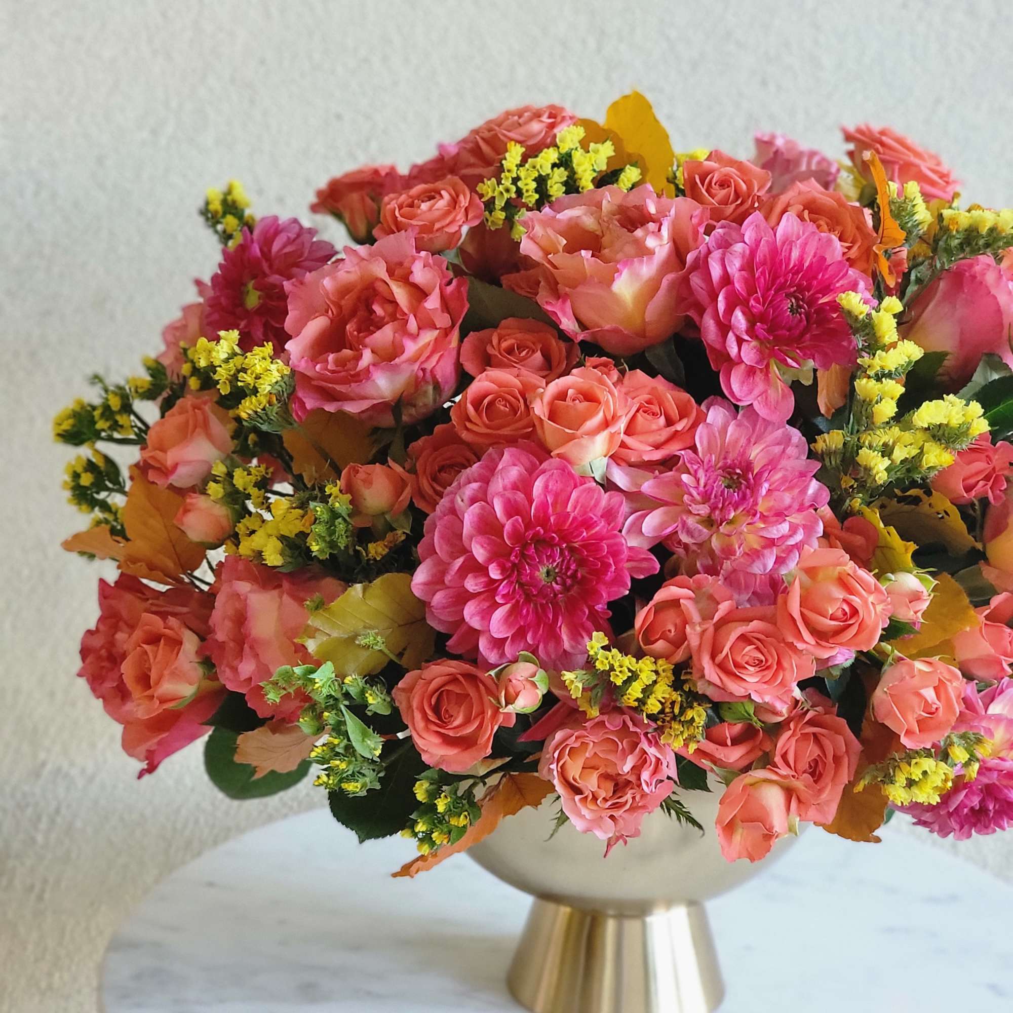 Bouquets and compositions of a bright flowers in a golden vase will