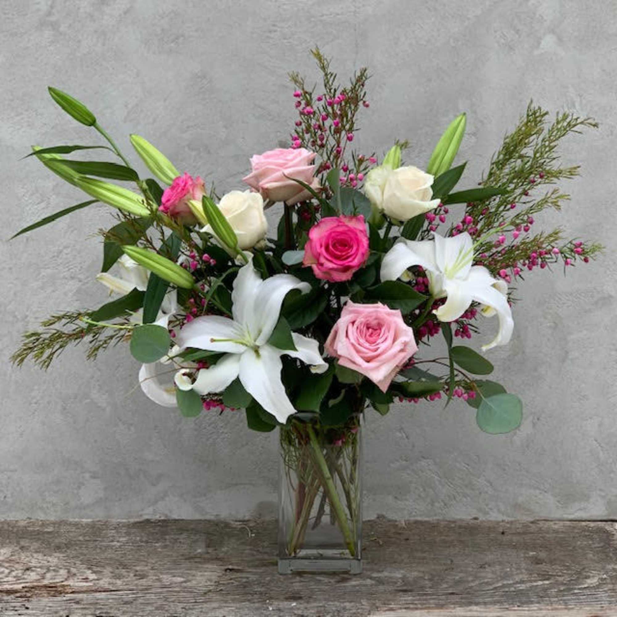 A beautiful bouquet of pink and white roses with white lilies in