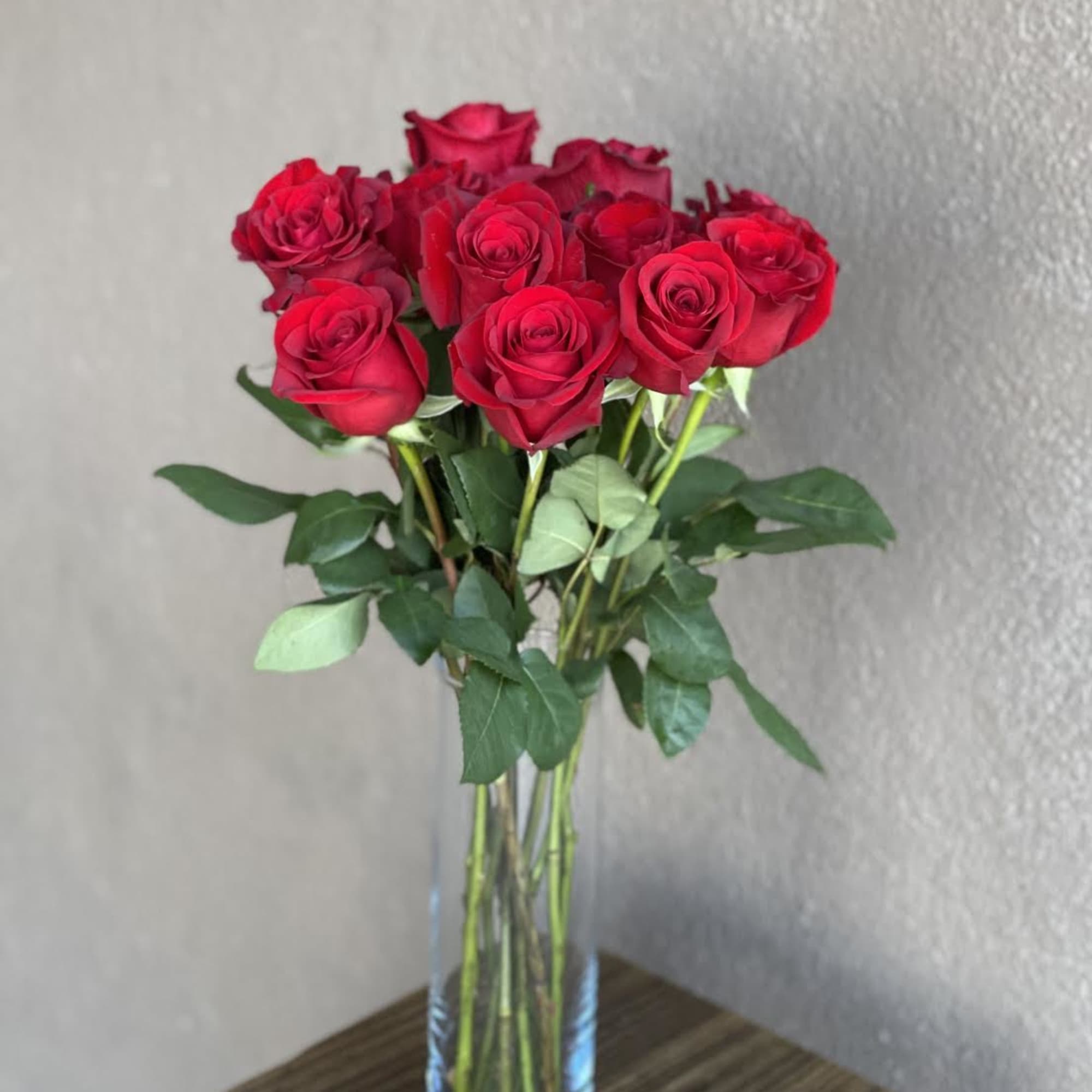 A dozen red roses in a vase make the perfect gift for