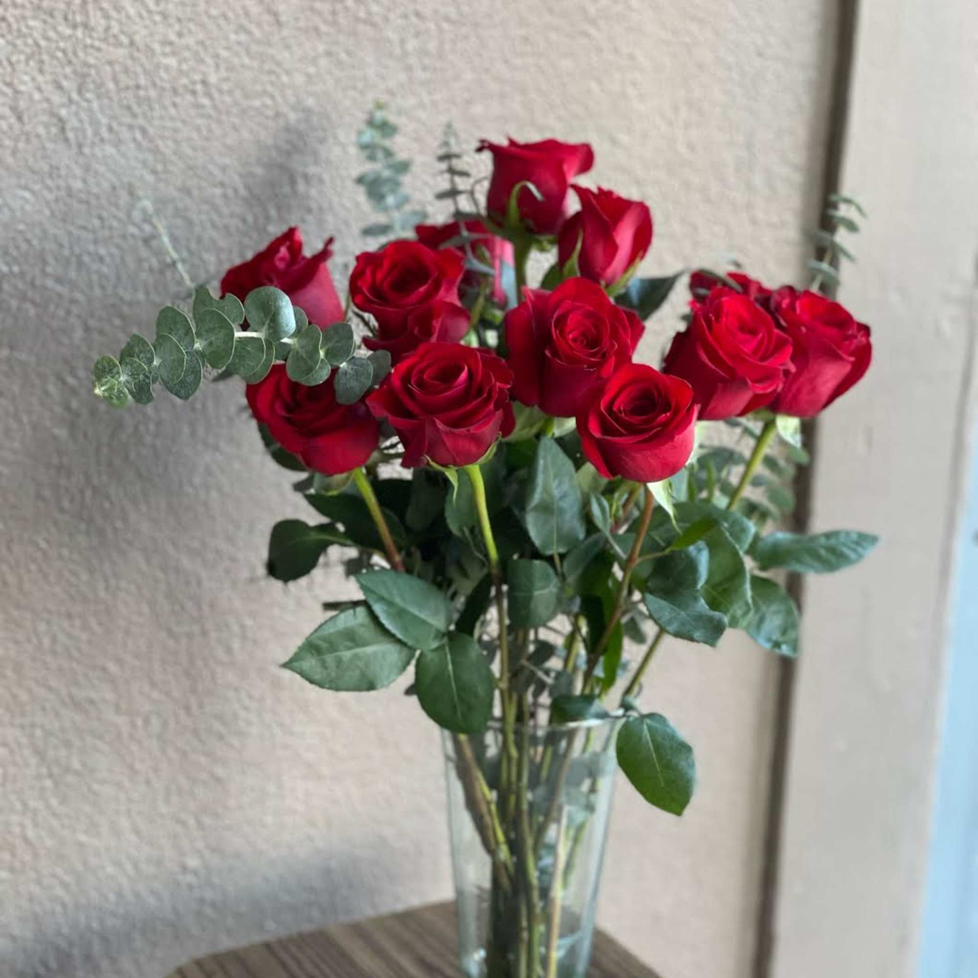 A dozen red roses in a vase make the perfect gift for