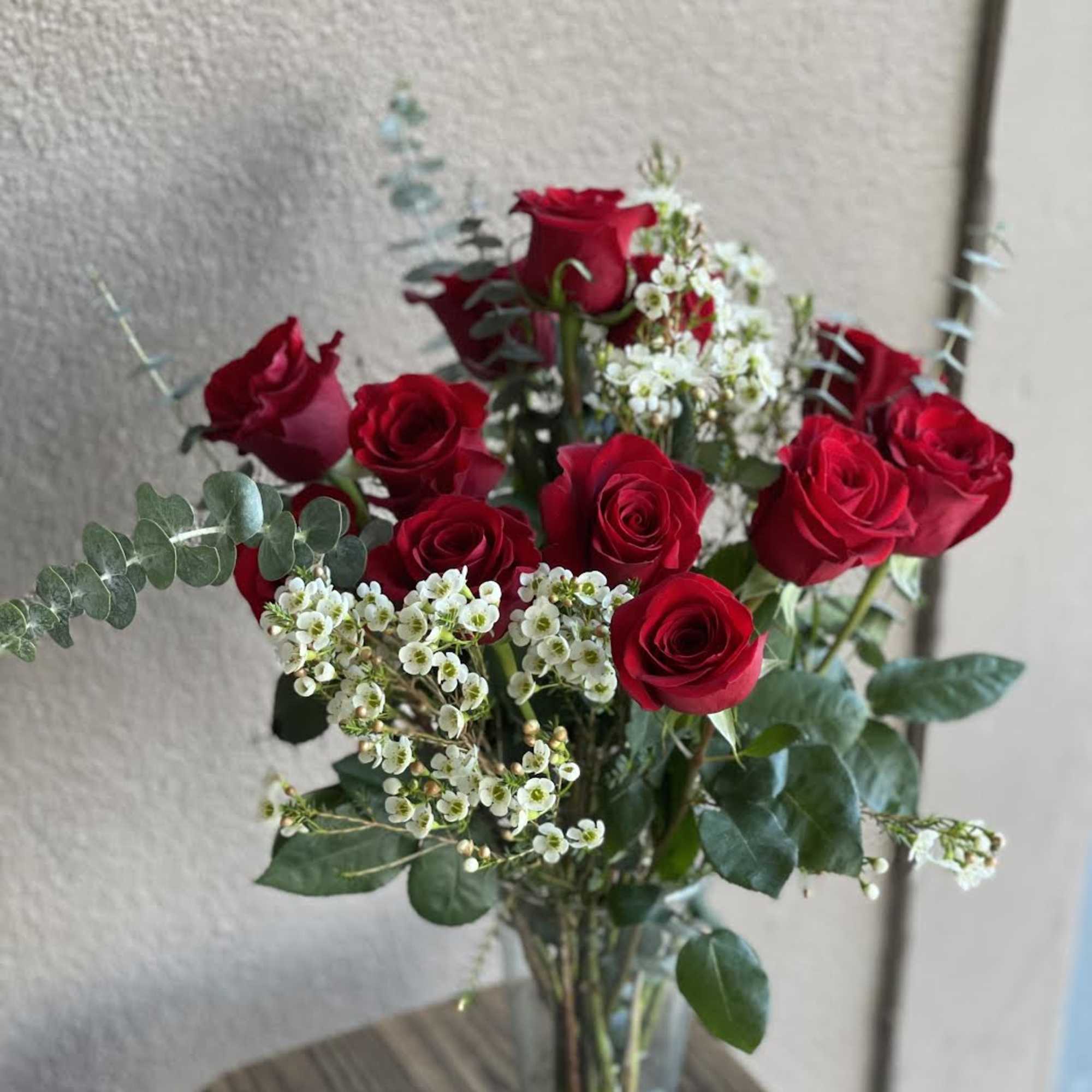 A dozen red roses in a vase make the perfect gift for
