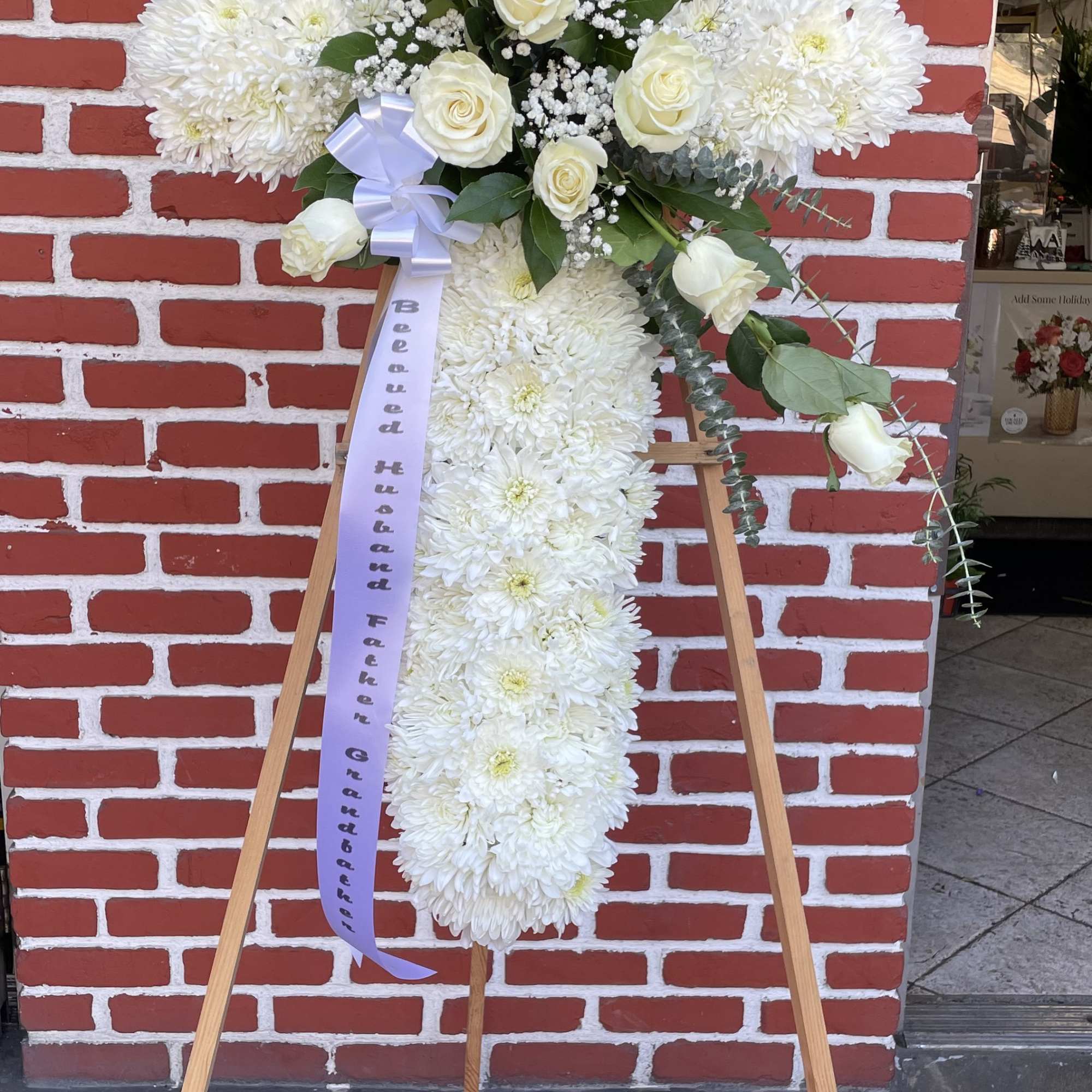 An all white tribute, this white cross funeral spray is pure and An all white tribute, this white cross funeral spray is pure and
