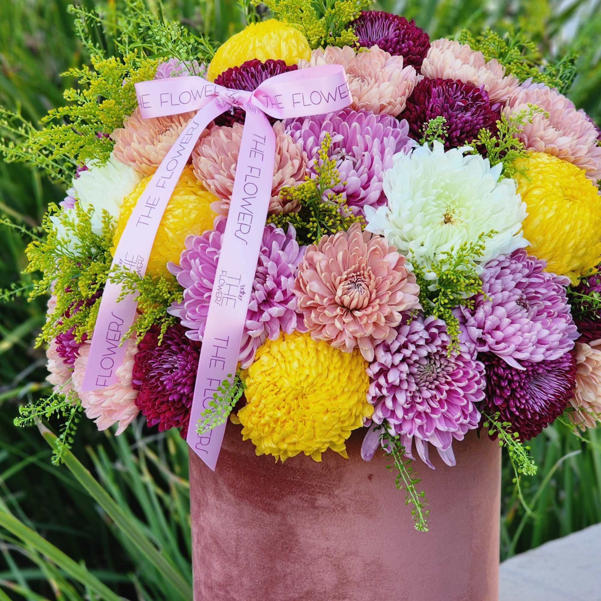 Burgundy, lavender, and yellow chrysanthemums in an elegant velvet box look exquisite