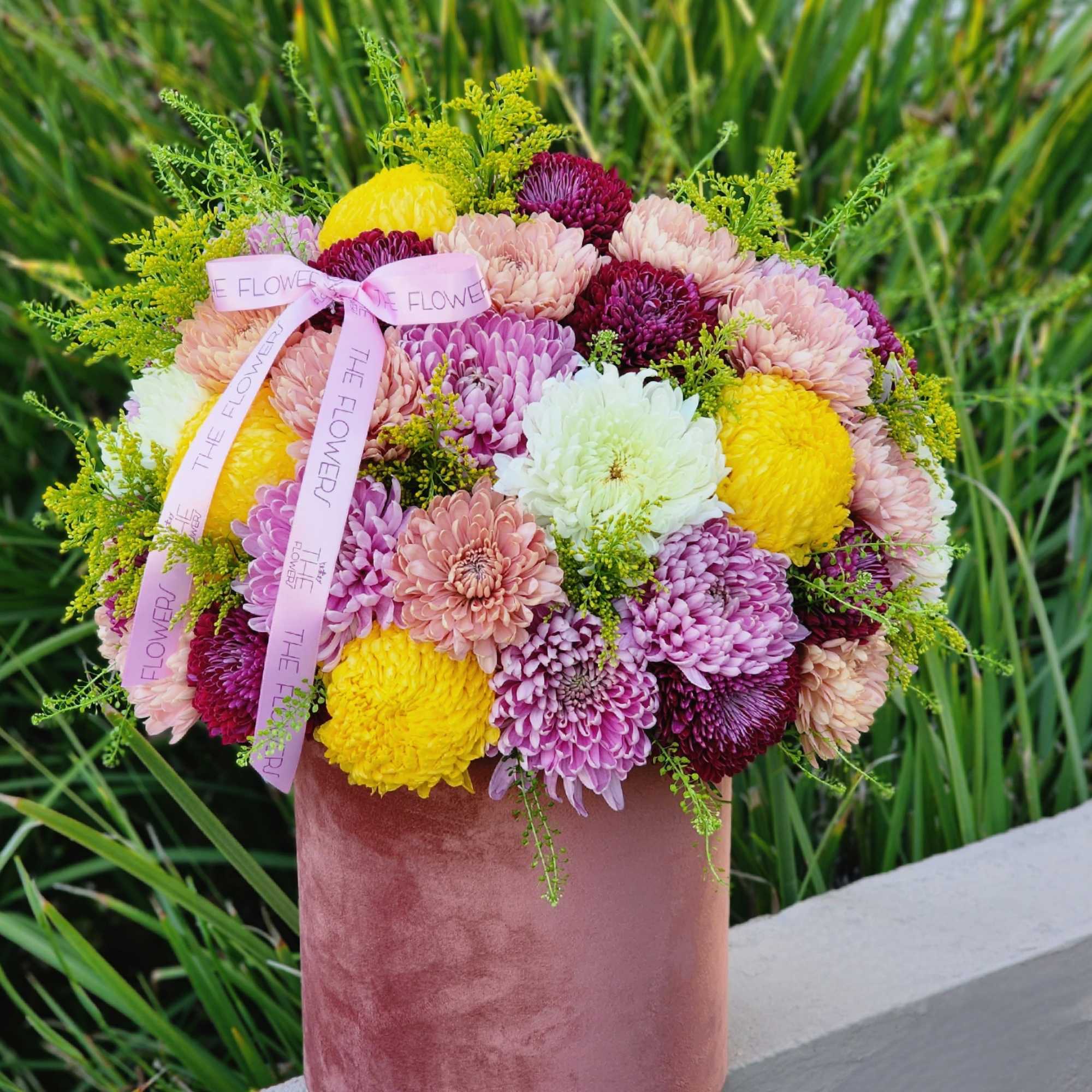 Burgundy, lavender, and yellow chrysanthemums in an elegant velvet box look exquisite