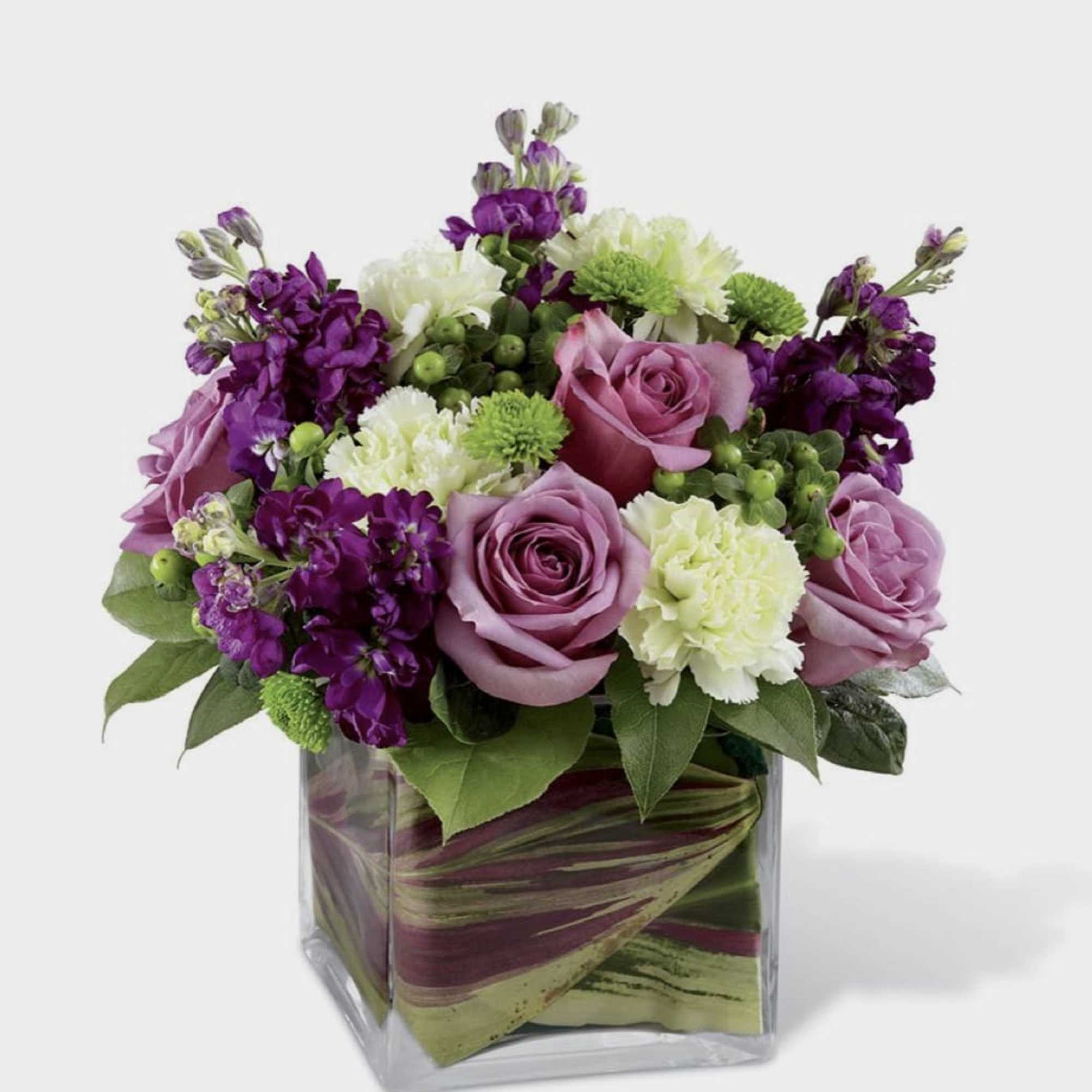 A lavender color centerpiece with roses and other beautiful seasonal flowers 