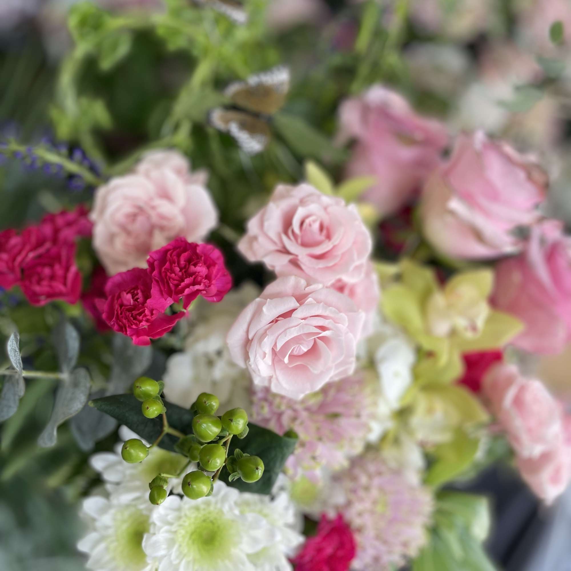 This beautiful arrangement has green orchid, bells of Ireland l, pink roses