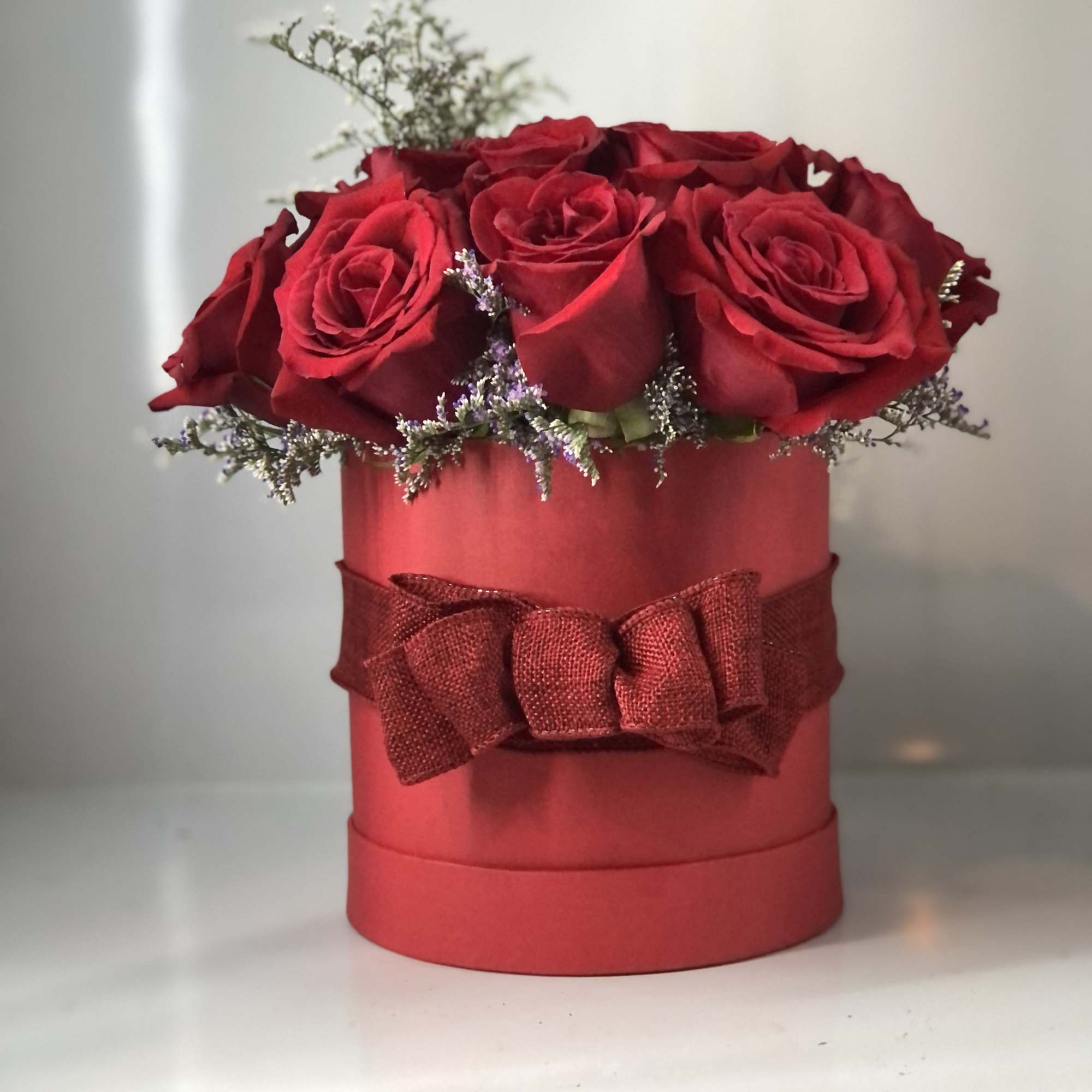 Red roses pillowed inside a round hat box