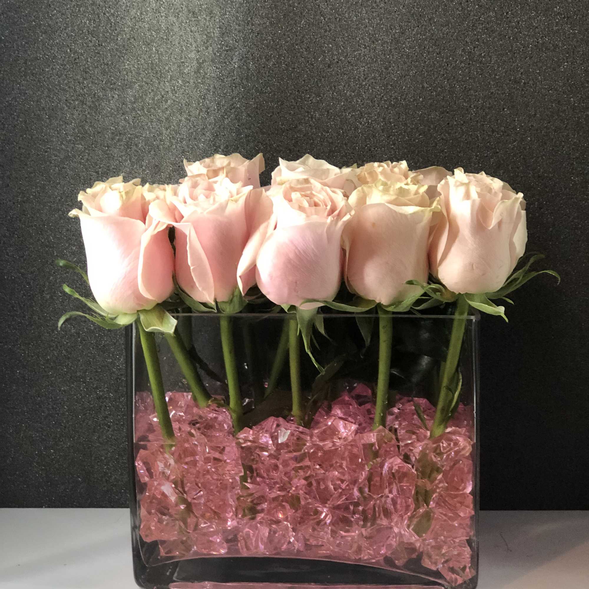 One dozen roses delicately pillowed on these stunning sapphire rocks