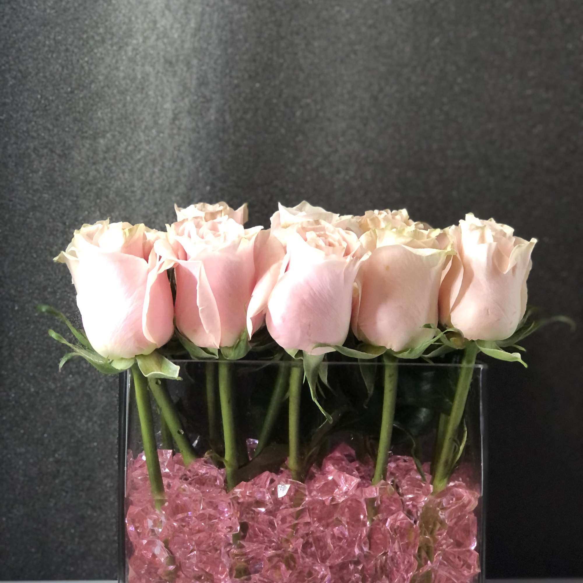 One dozen roses delicately pillowed on these stunning sapphire rocks