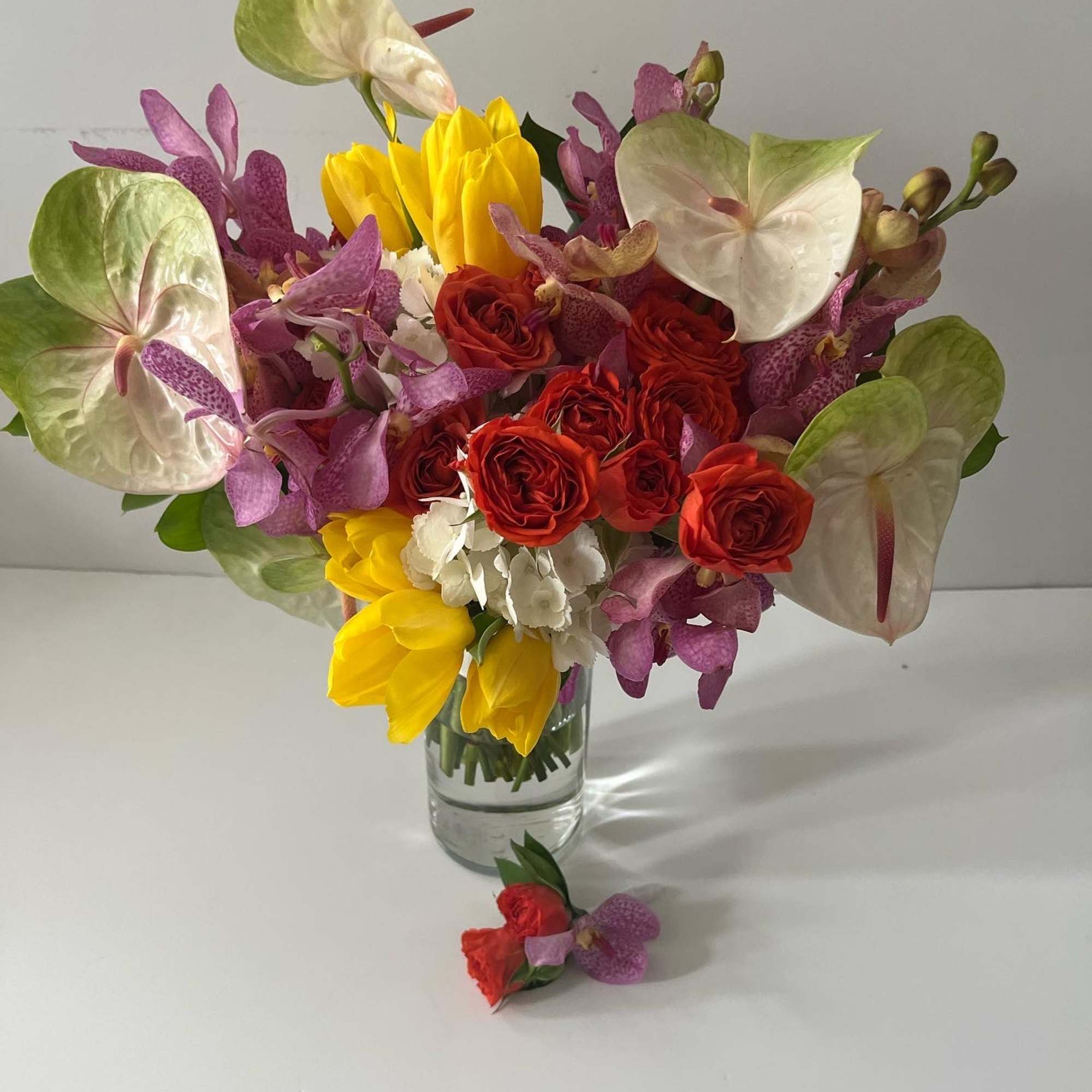 A combination of seasonal garden and tropical blooms selected by color scheme.