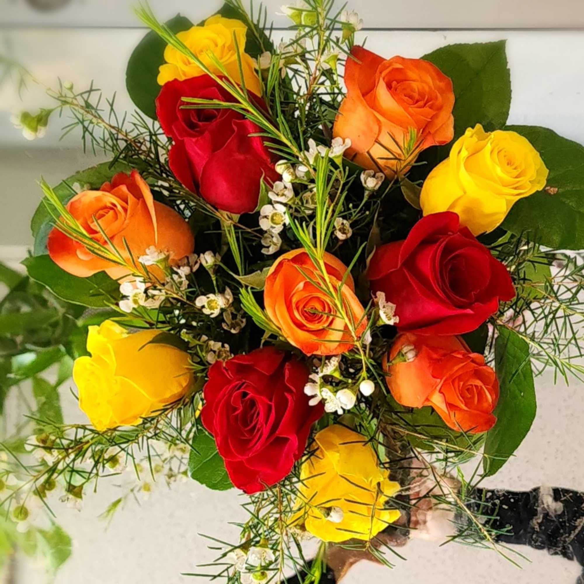 A Classic mix of pink, purple, yellow, and peach roses accented with