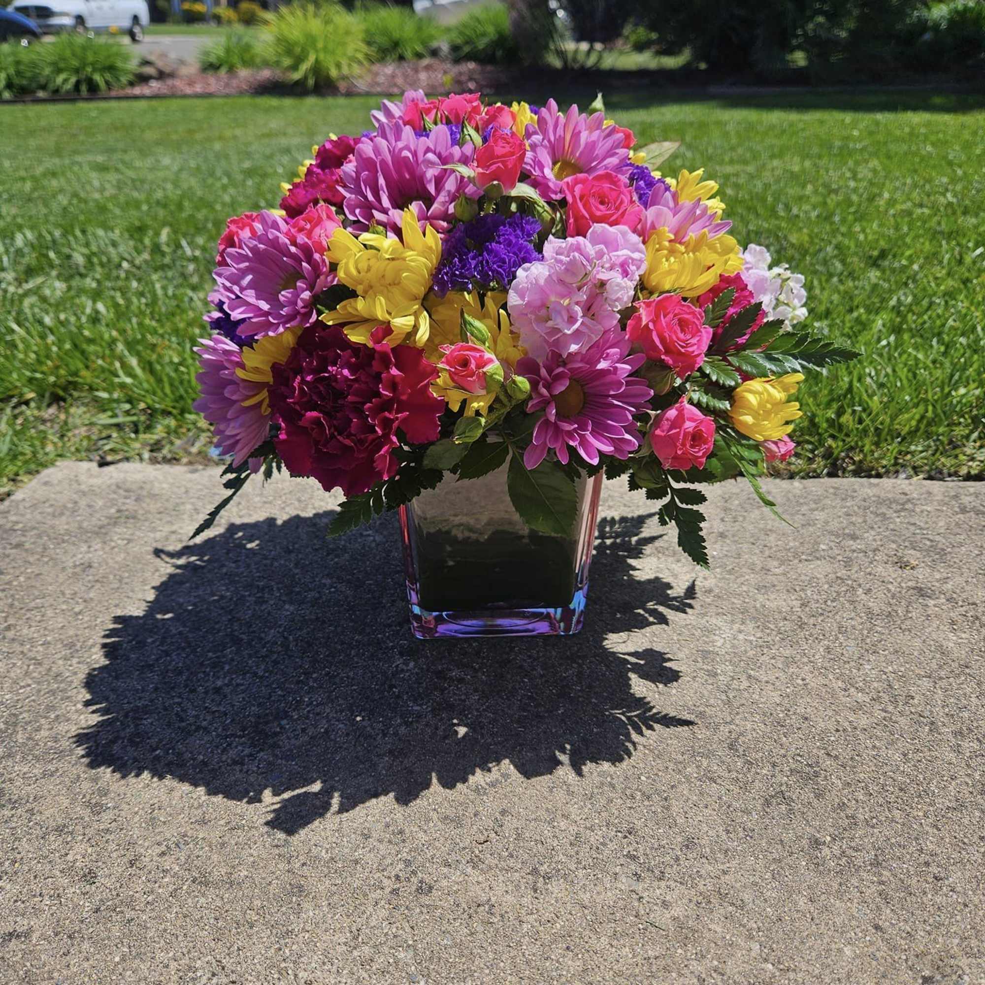 A mix of fresh flowers of all colors in a cube