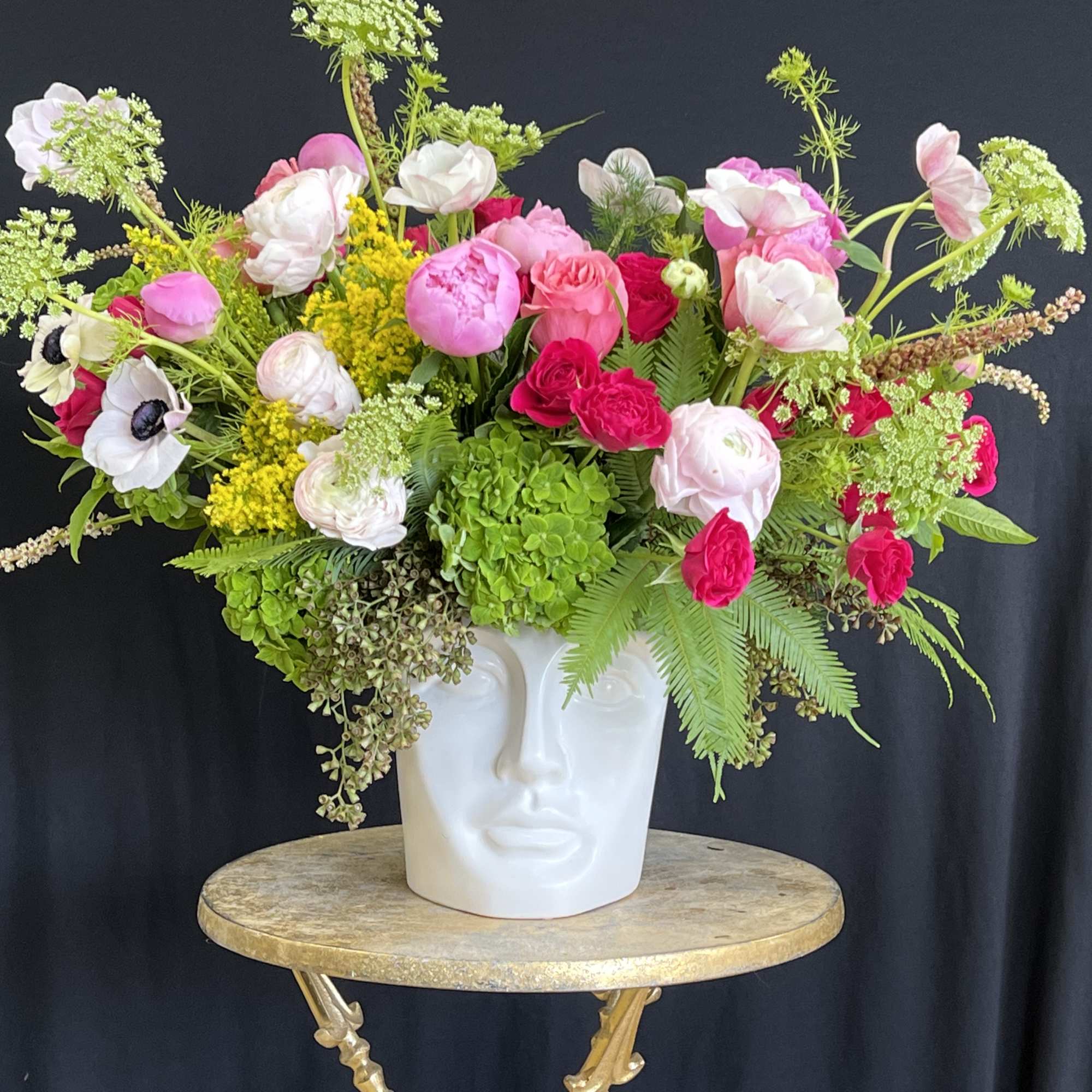 A modern arrangement of vibrant orchids and sculptural greens.