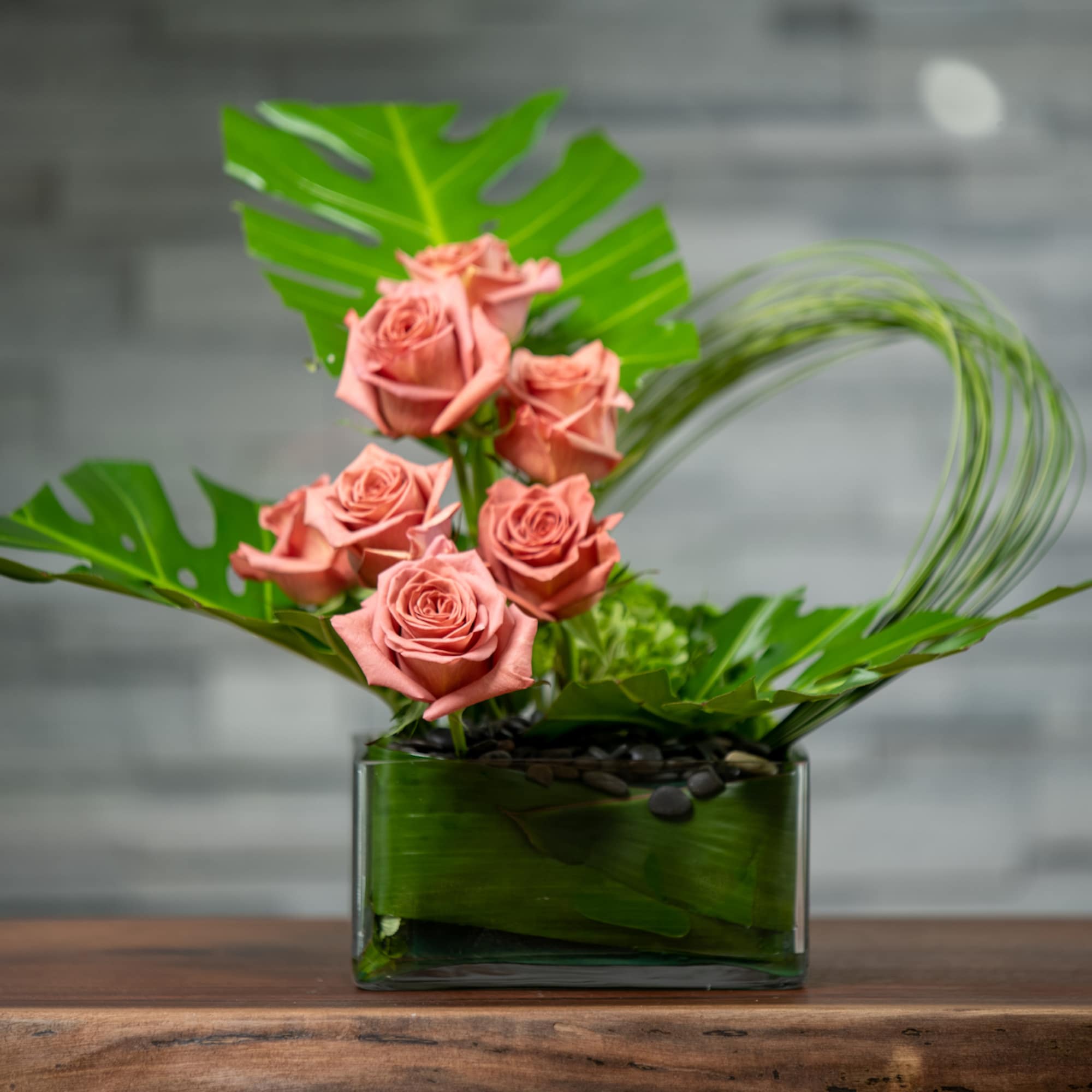 Minimalist and modern combination of terra cotta roses, looping grasses and tropical Minimalist and modern combination of terra cotta roses, looping grasses and tropical