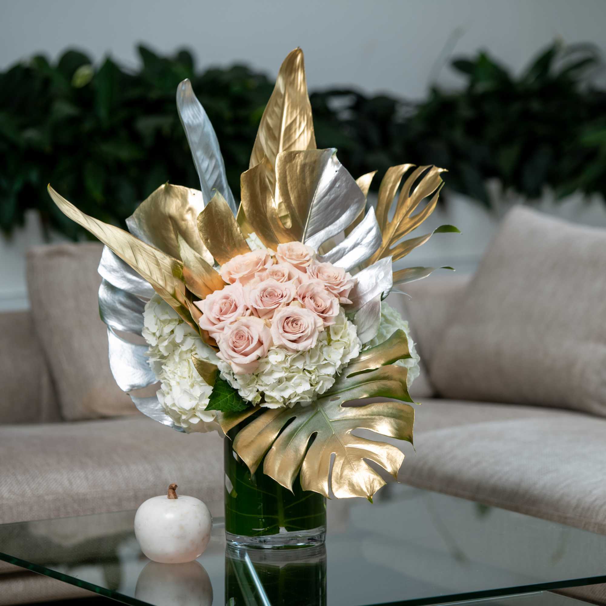 Painted silver and gold metallic leaves surround a grouping of beige roses.