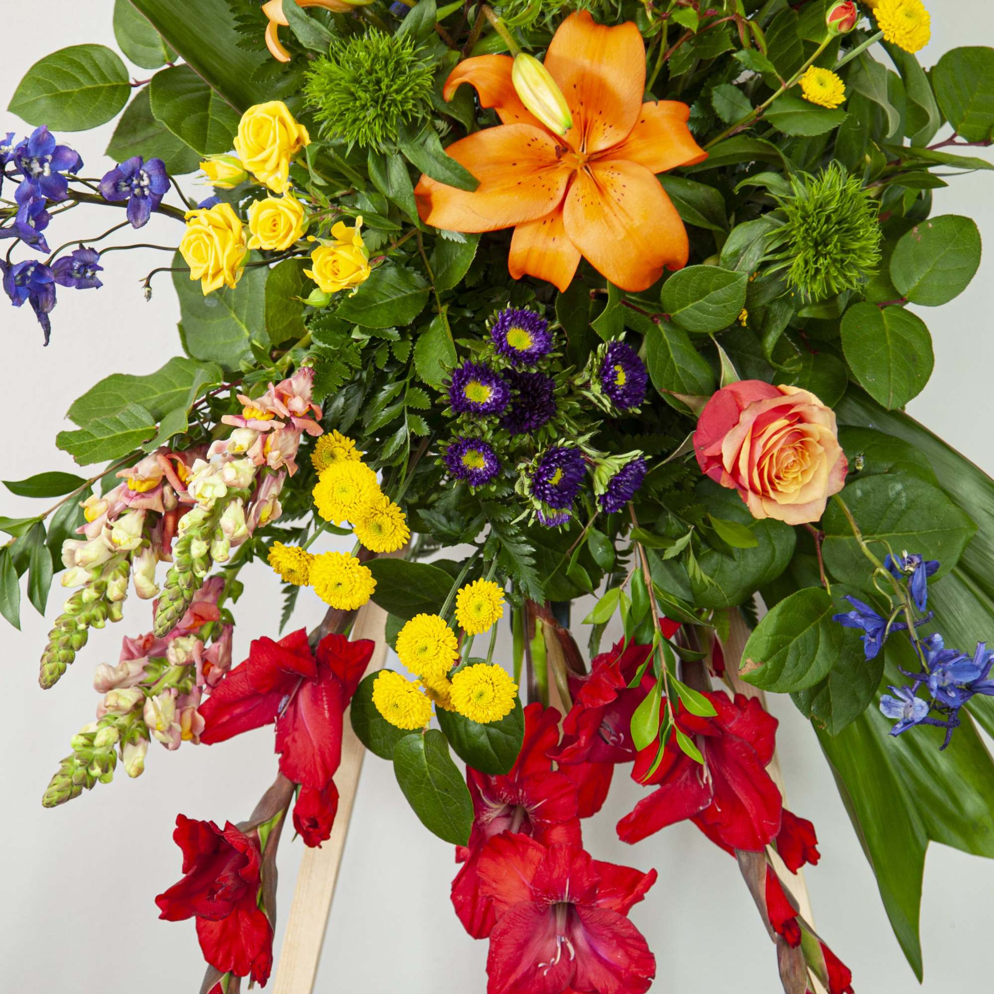 This colorful standing spray is made with a sunset-inspired color palette, and This colorful standing spray is made with a sunset-inspired color palette, and