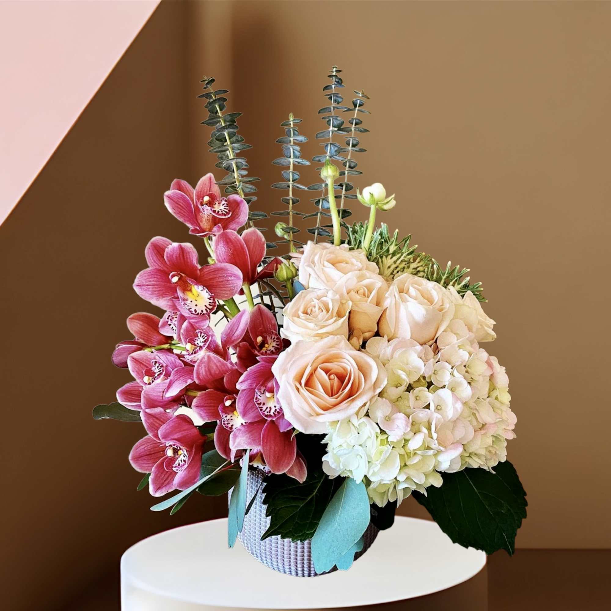 Cymbidium Orchids and Roses in a ceramic vase with hydrangea, eucalyptus and