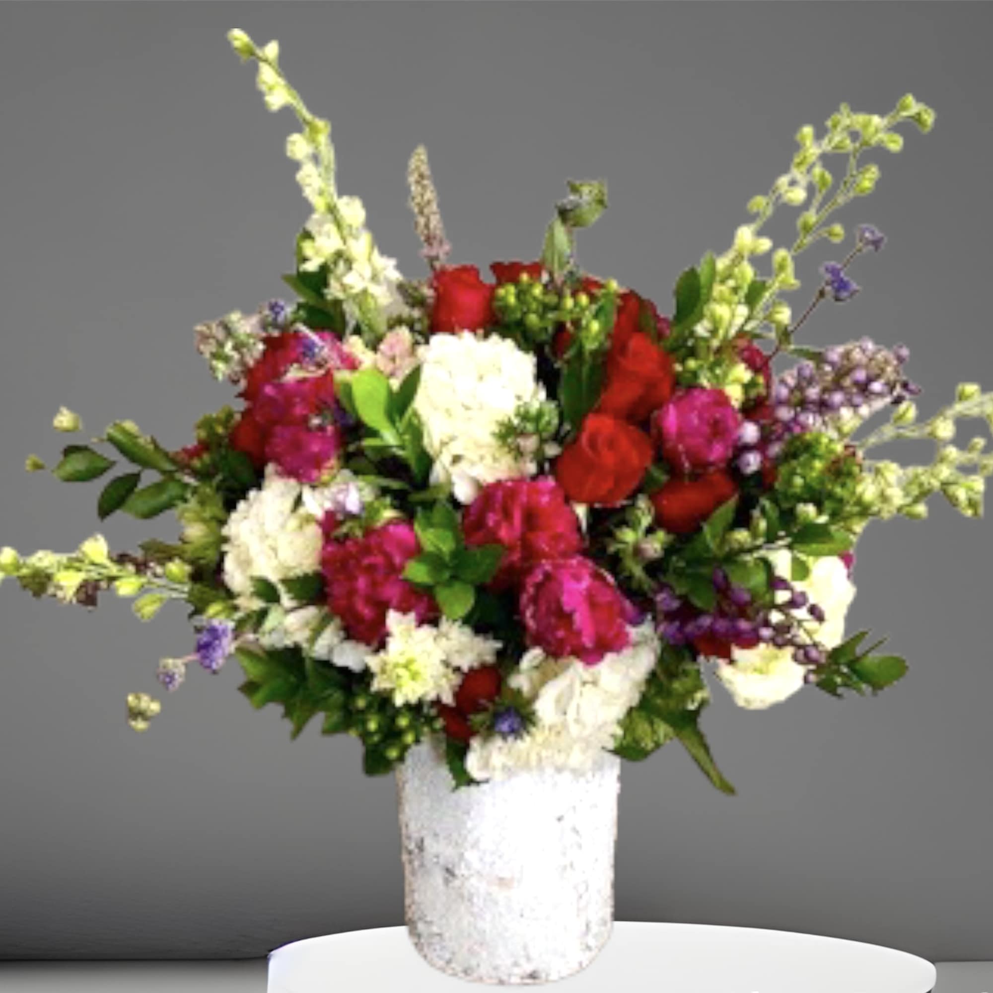 A lovely colorful winter mix of roses, hydrangea, berries, and other seasonal