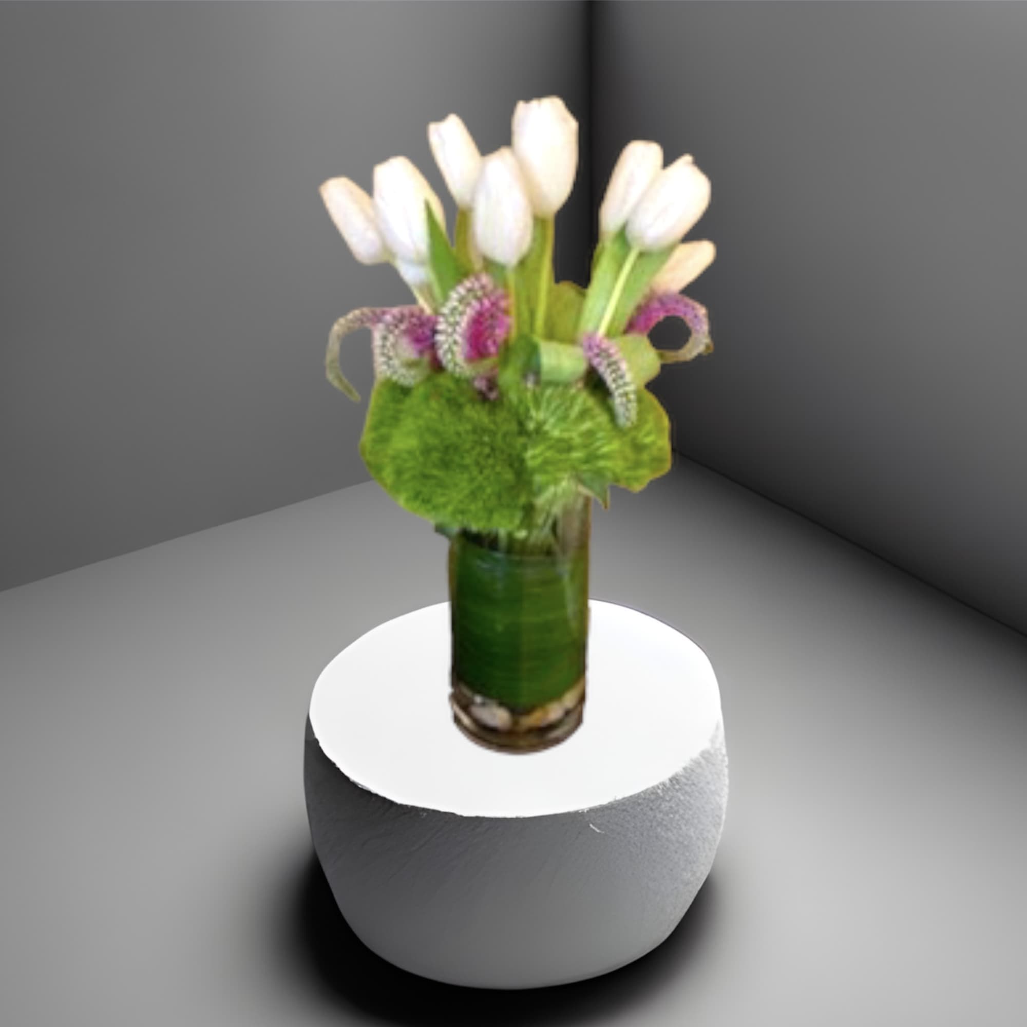 An arrangement of tulips in a glass cylinder vase with river rocks