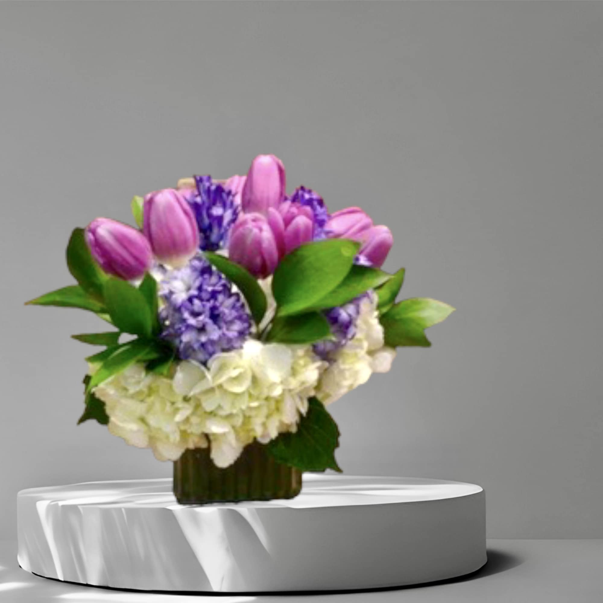 A Spring mix of lavender tulips, purple hyacinth, and hydrangea in a