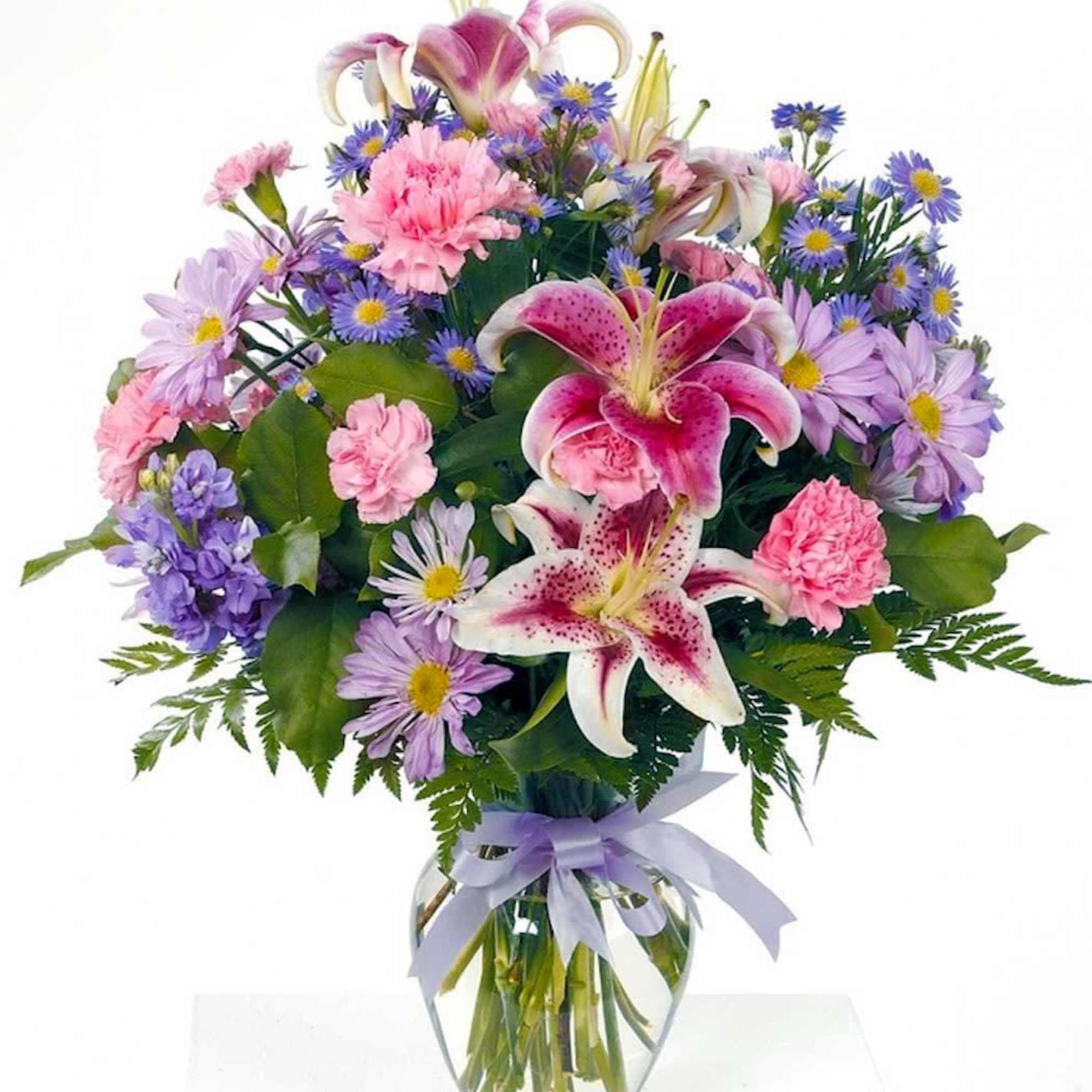 Beautiful stargazer lilies in a glass vase with pink carnations, lavender daisies