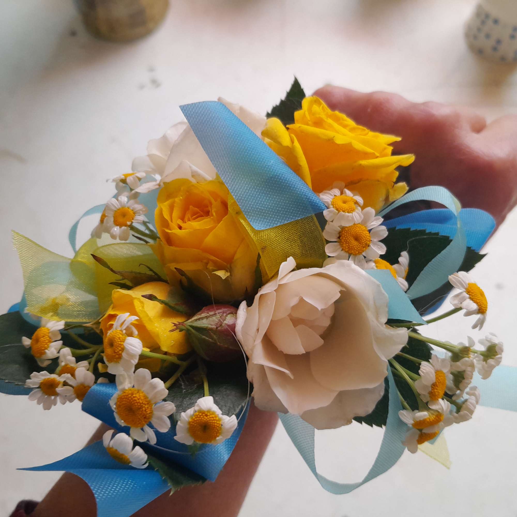 Beautiful warm midsummer wedding colors of yellow roses, light blue delphinium and