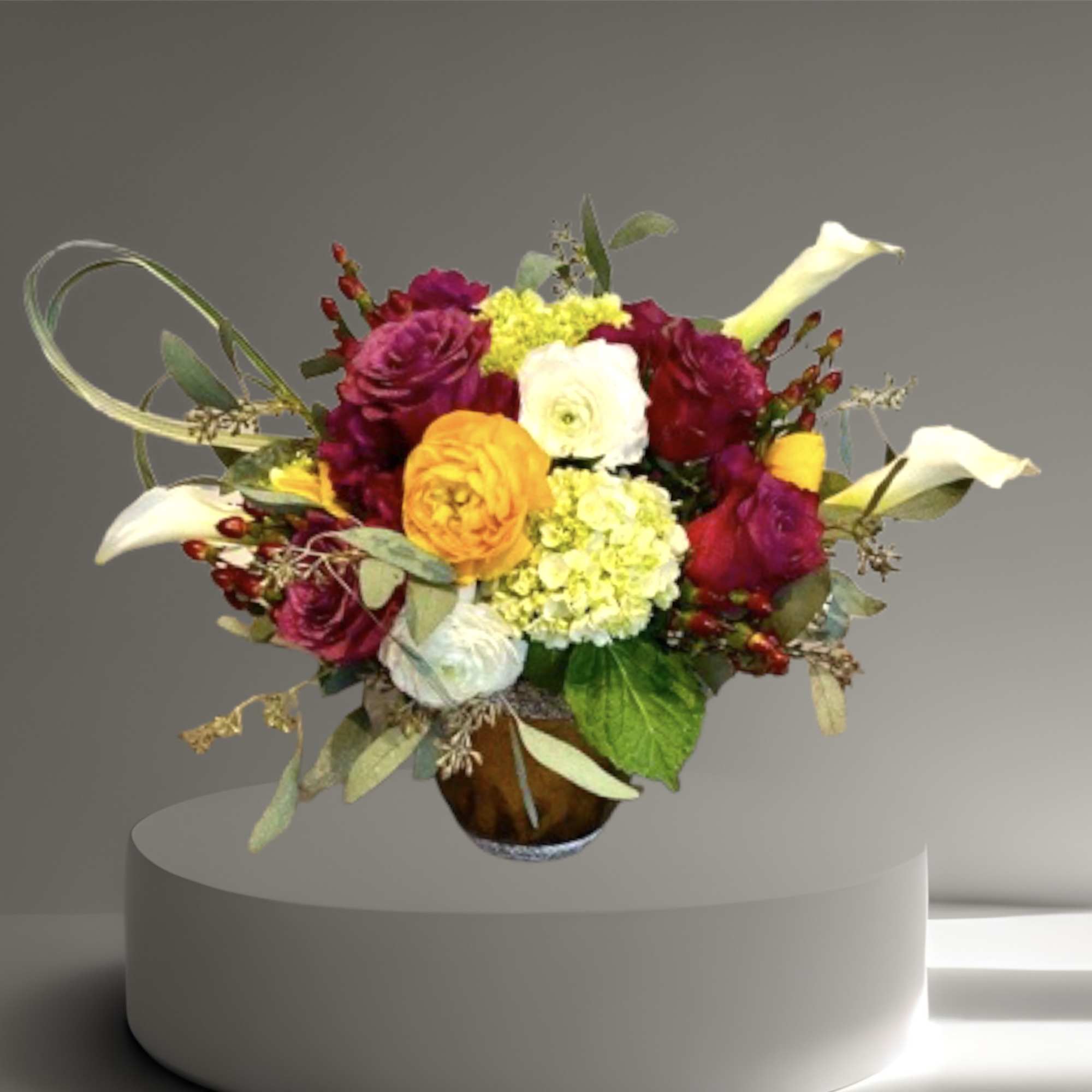 A lovely mix of roses, calla lilies, hydrangea, hypericum berries, and seasonal